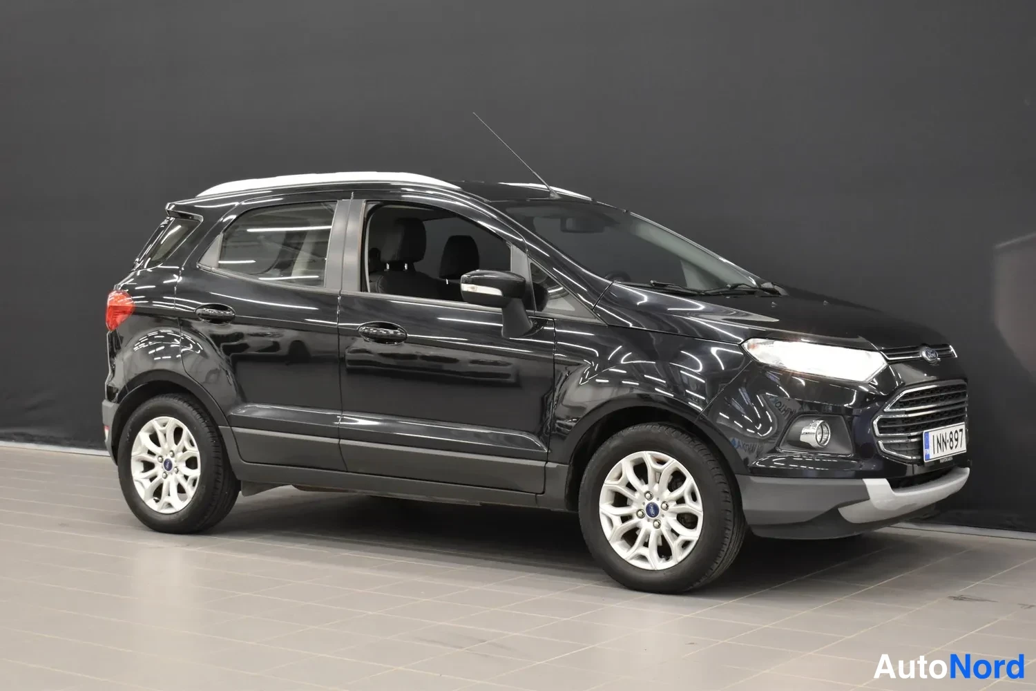 Etuviisto, nokka oikealle: Mustan Ford EcoSportin etukulmanormaalikuva oikealta, rekisterikilpi.