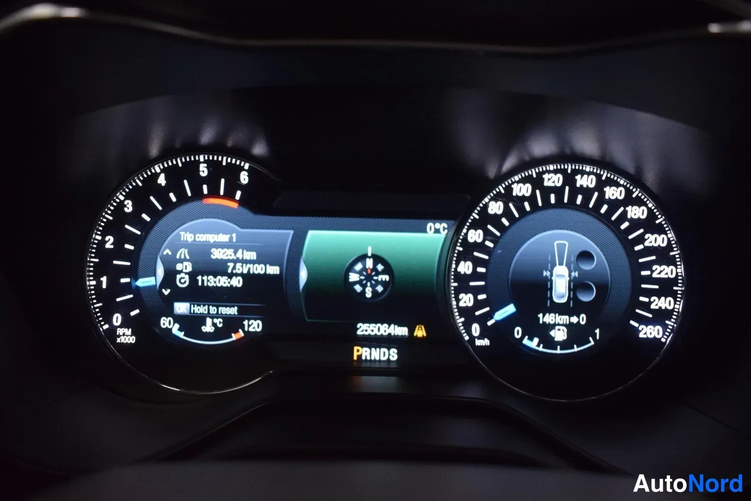 Edestä: Mittaristö taustavalot: vasen kierrosmittari 0–8000 rpm, oikea nopeusmittari 0–260 km/h, keskellä 255064 km kokonaiskilometrit ja P R N D S -vaihdetila.