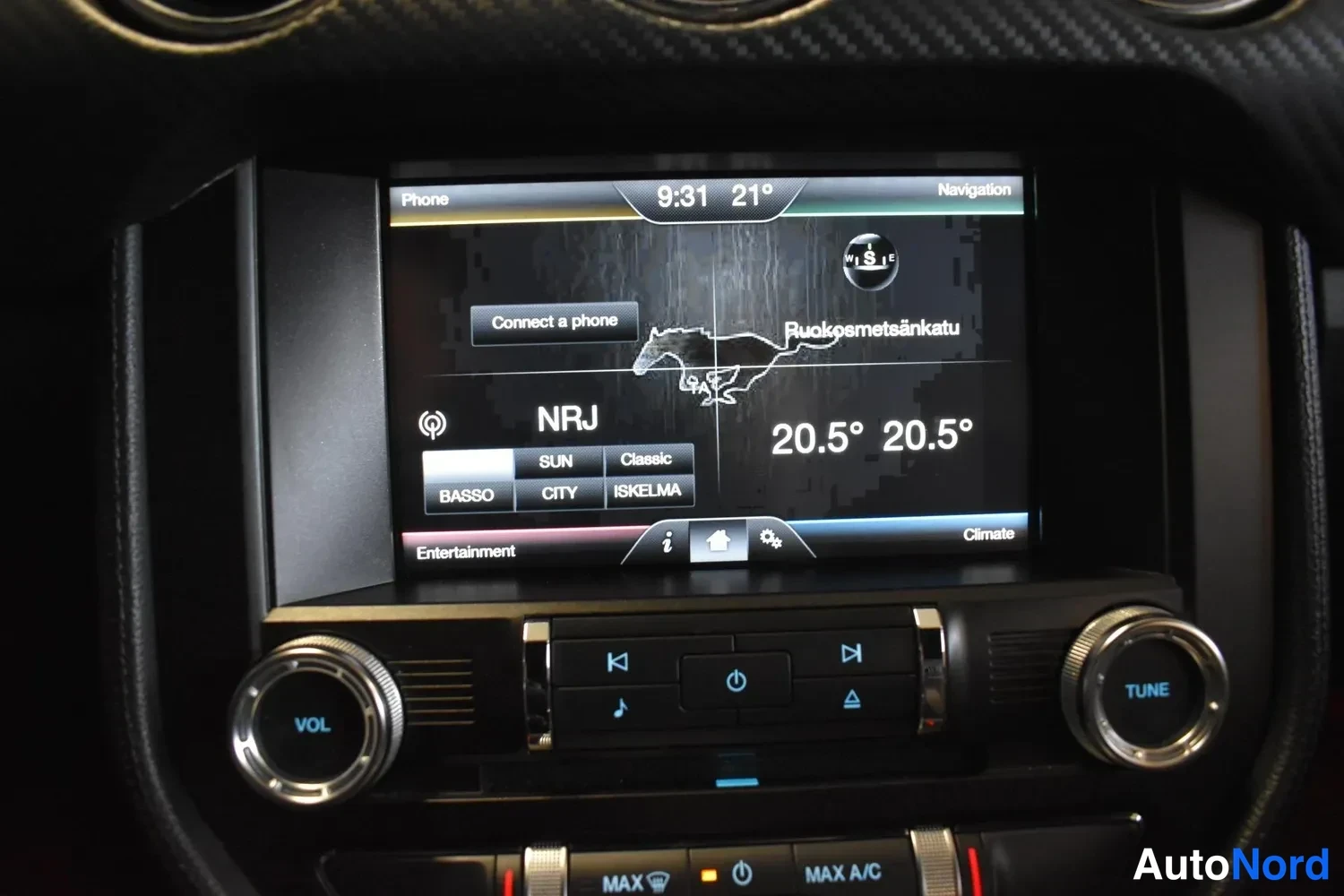 Muu: Ford Mustangin kosketusnäytön navigaatio- ja viihdejärjestelmä näyttää kelloa 9:31, lämpötiloja 20,5° ja kanavaa NRJ.