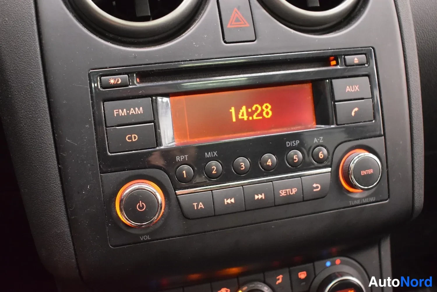 Muu: Kojelaudan radio/CD-yksikkö, jonka näytössä lukee 14:28 ja painikkeet FM·AM, CD, AUX ja SETUP näkyvät.
