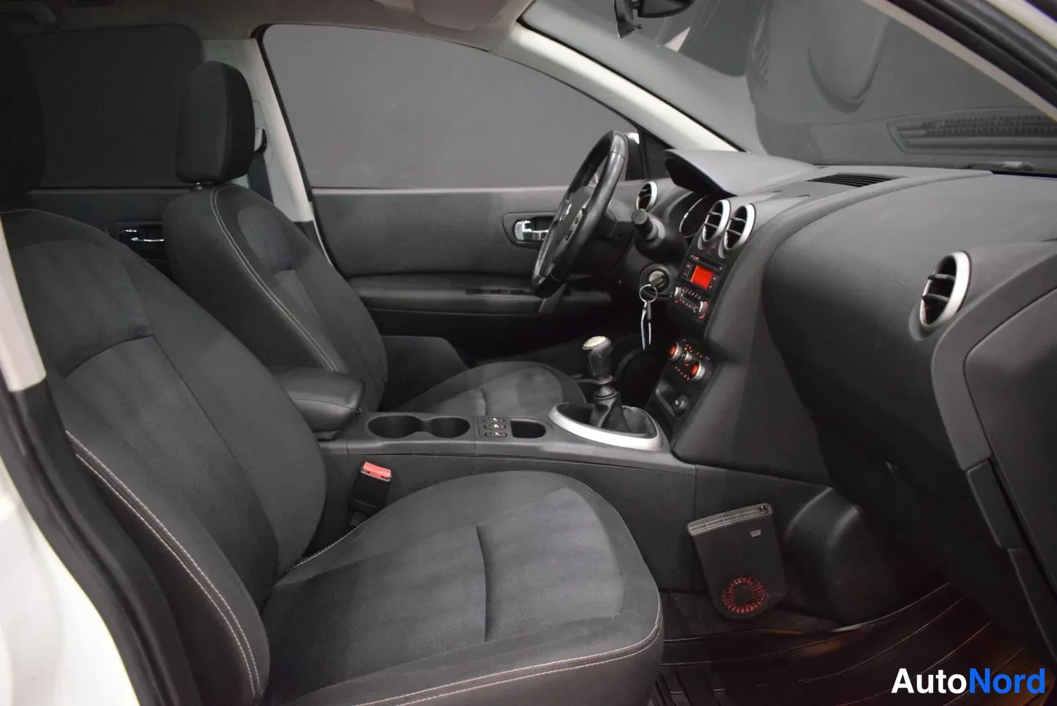 Muu: Auton etusumu musta：Nissanin etupenkki-istuimet ja kojelauta, portaittainen manuaalivaihteisto.