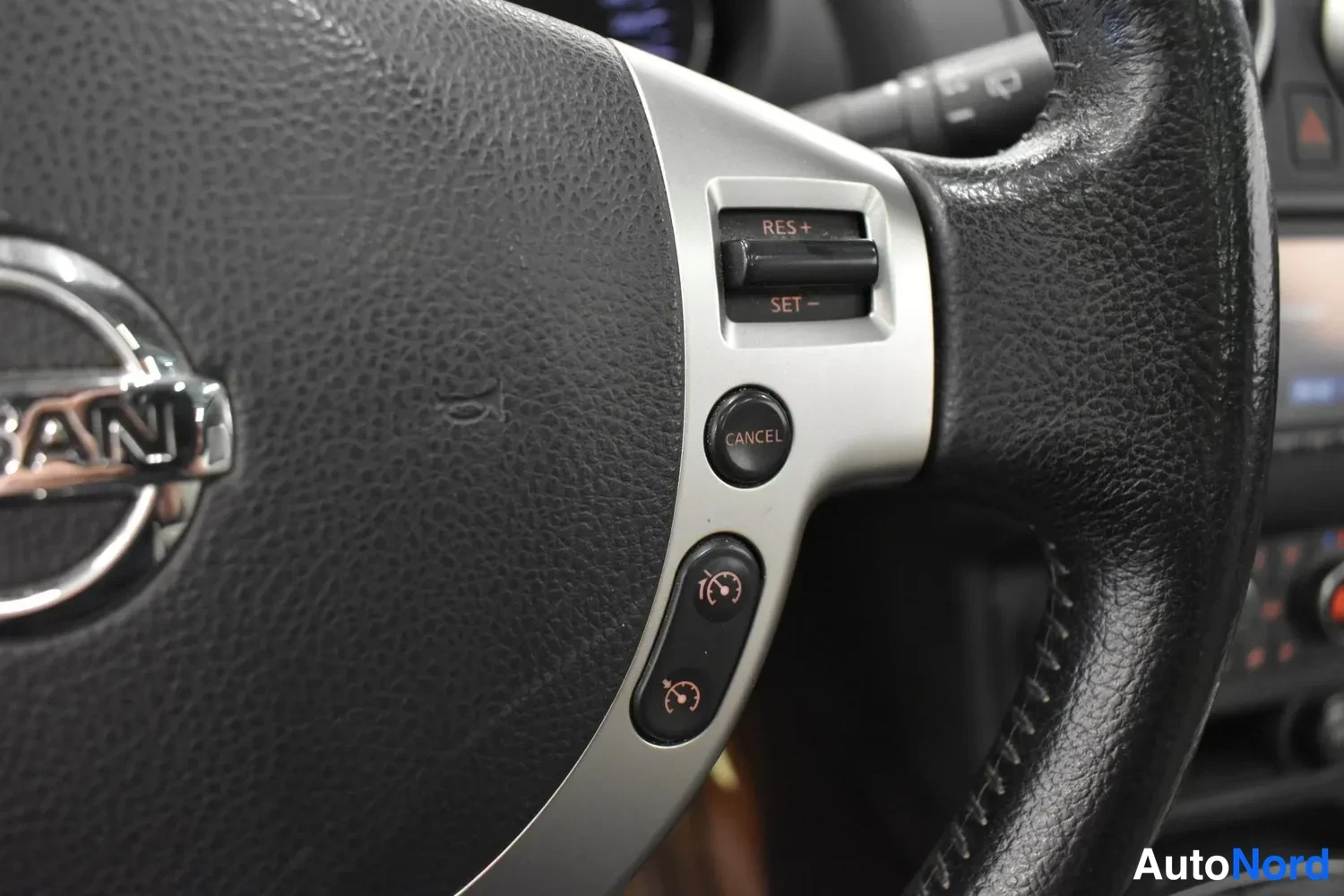 Yksityiskohta: Ohjauspyörän oikean pujon cruise control -kytkimet RES+ ja SET− sekä CANCEL-painike.