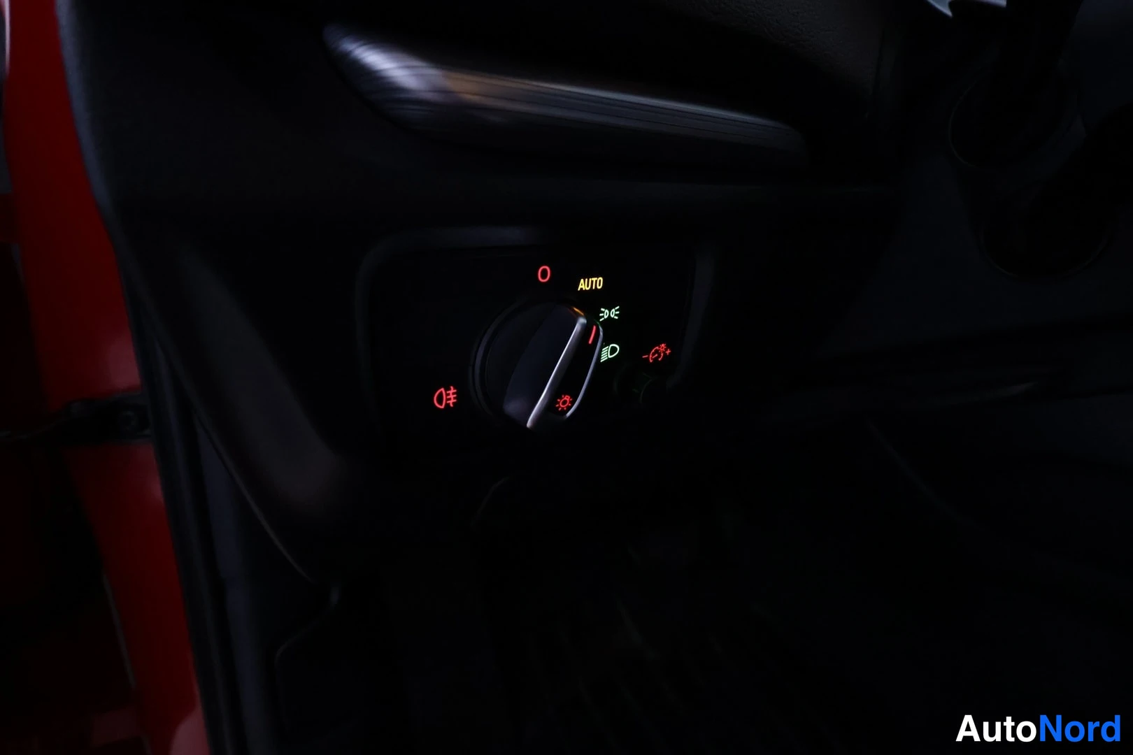 Muu: Valaisinkytkin ominaisvalo-asetuksella (AUTO) kuvattuna lähikuvana pimeässä ohjaamossa.