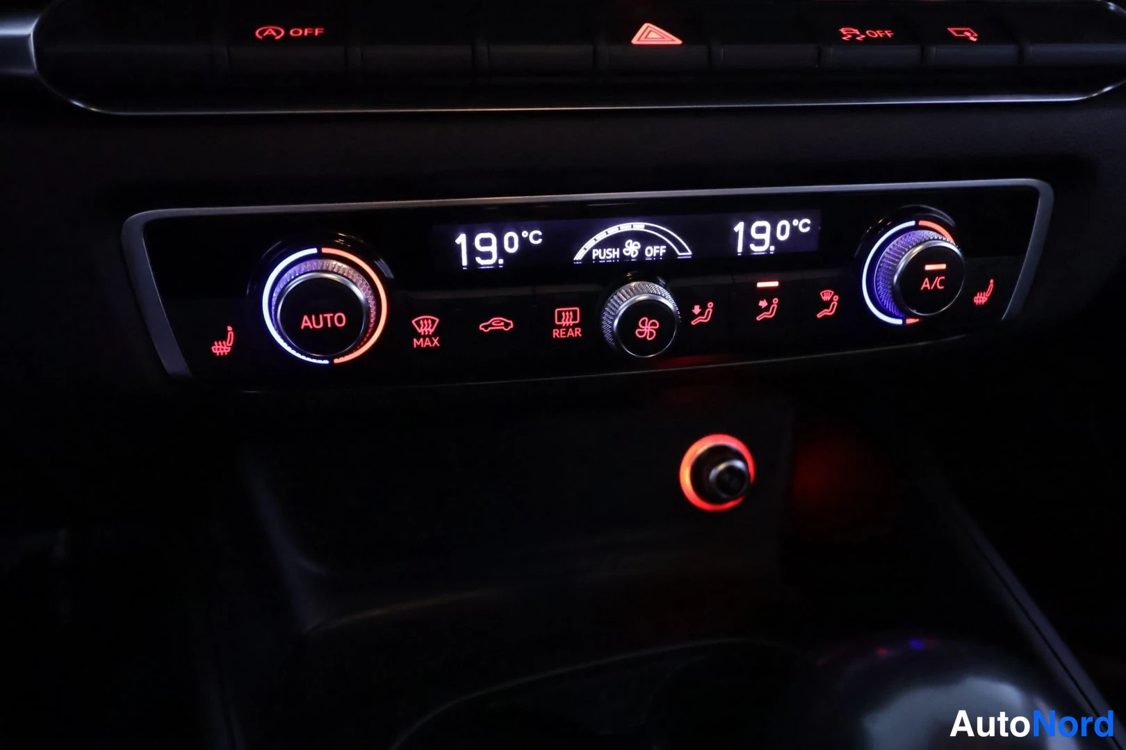 Muu: Lähikuva ilmastointilaitteen ohjauksesta, jossa näkyvät AUTO- ja A/C-säätimet sekä molemmin puolin lukema 19,0 °C.