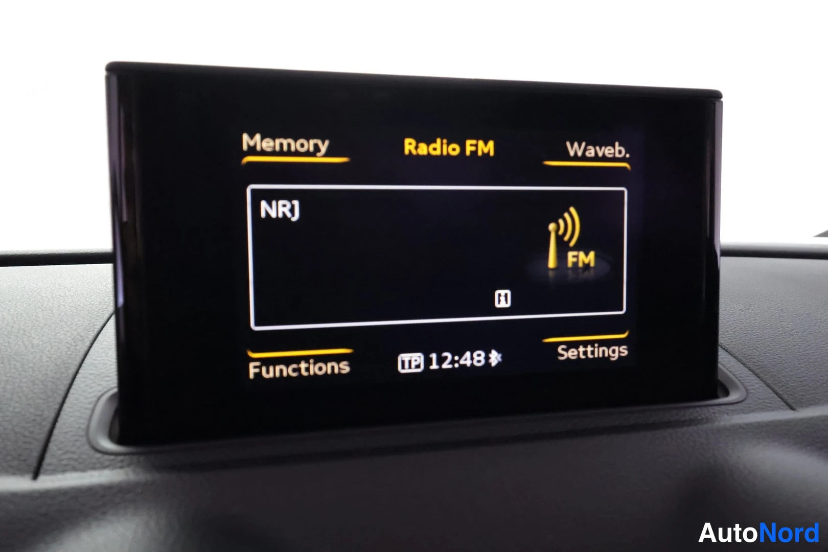 Yksityiskohta: Kojelaudan näyttö, radio FM kanava NRJ, kello 12:48
