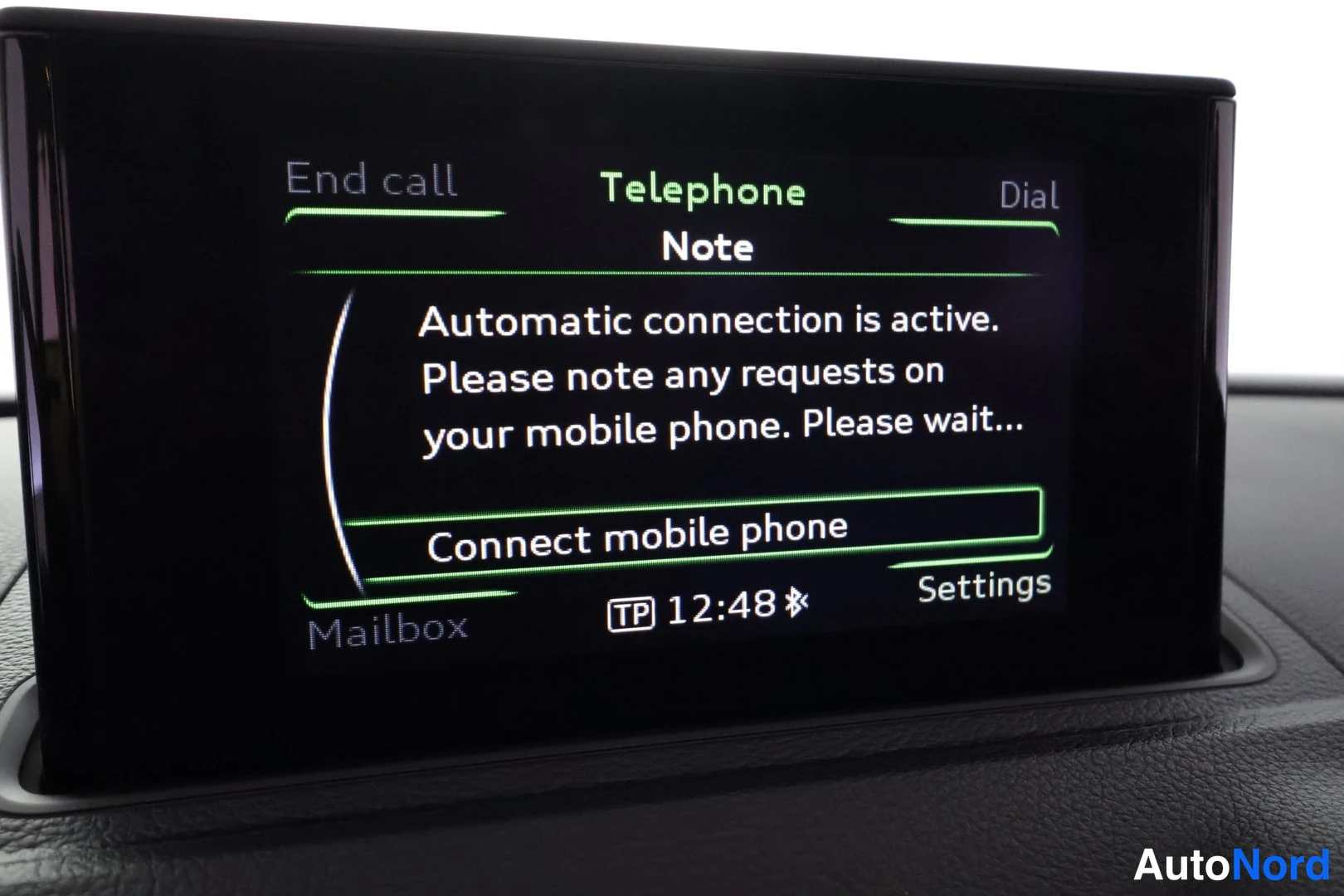 Yksityiskohta: Kojelaudan infotainment-näyttö, jossa puhelinvalikko ja teksti 'Automatic connection is active' sekä vaihtoehdot End call, Dial, Mailbox ja Settings.