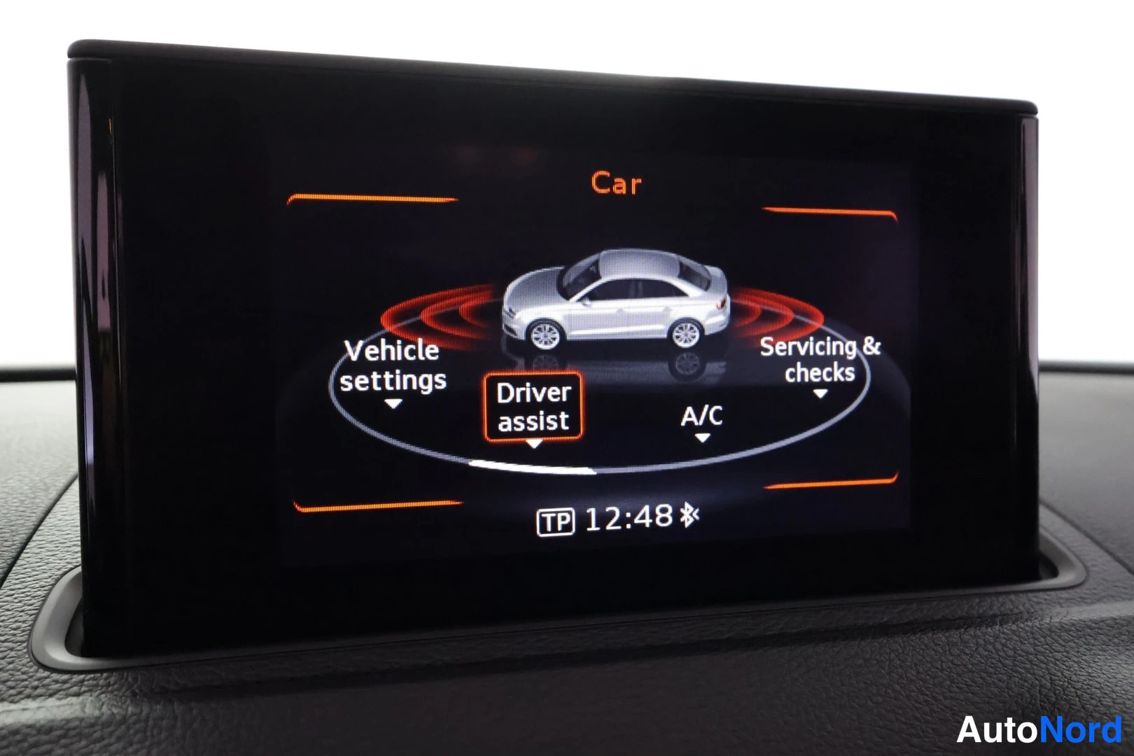 Muu: Audi A3 Sedanin kojelaudan näyttö Car-valikossa vaihtoehdoilla Vehicle settings, Driver assist, A/C ja Servicing & checks, kello 12:48.