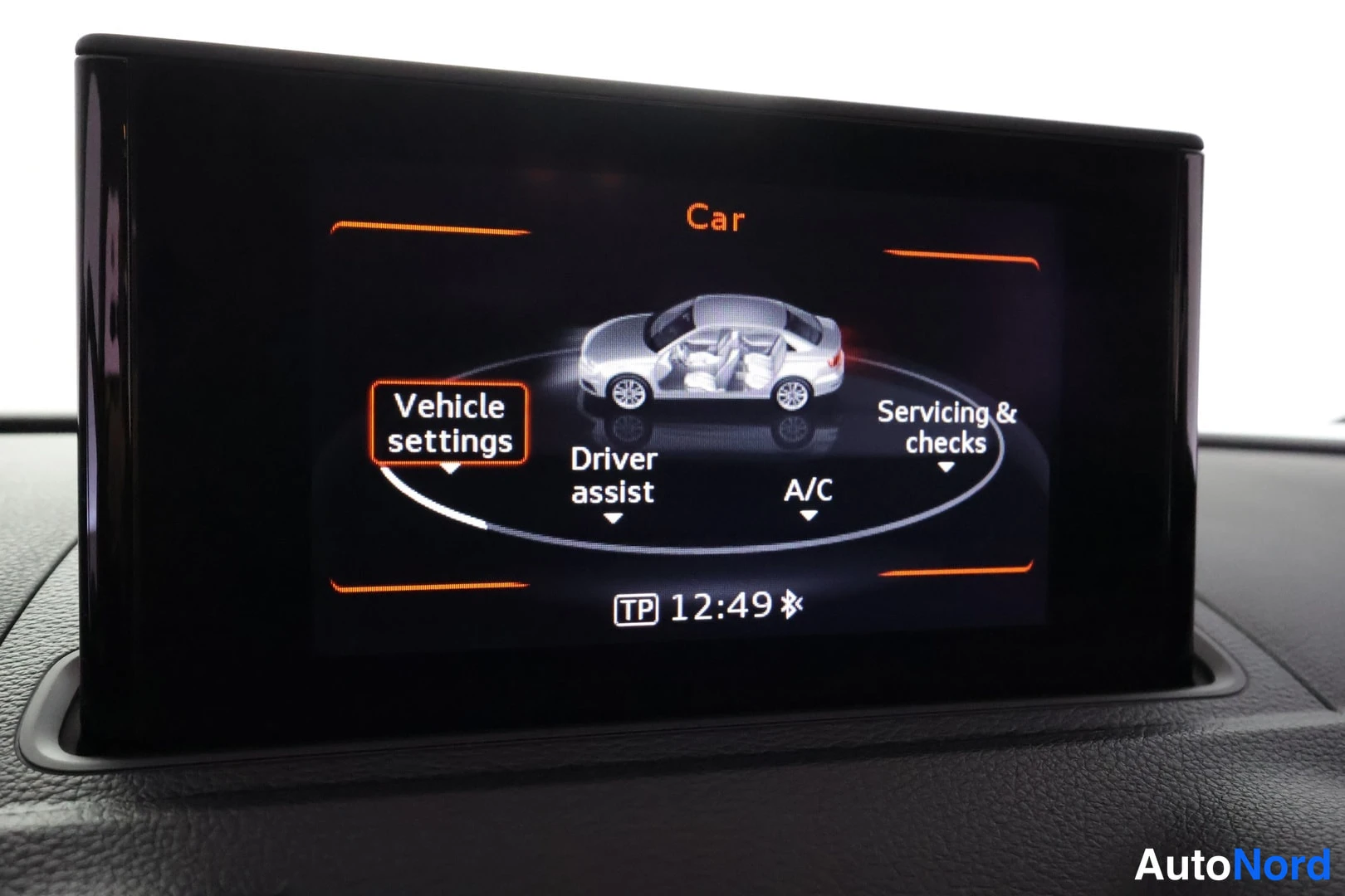 Muu: Audi A3 Sedanin kojelaudan näyttö Car-valikossa, korostettuna Vehicle settings; muut valinnat Driver assist, A/C ja Servicing & checks, kello 12:49.
