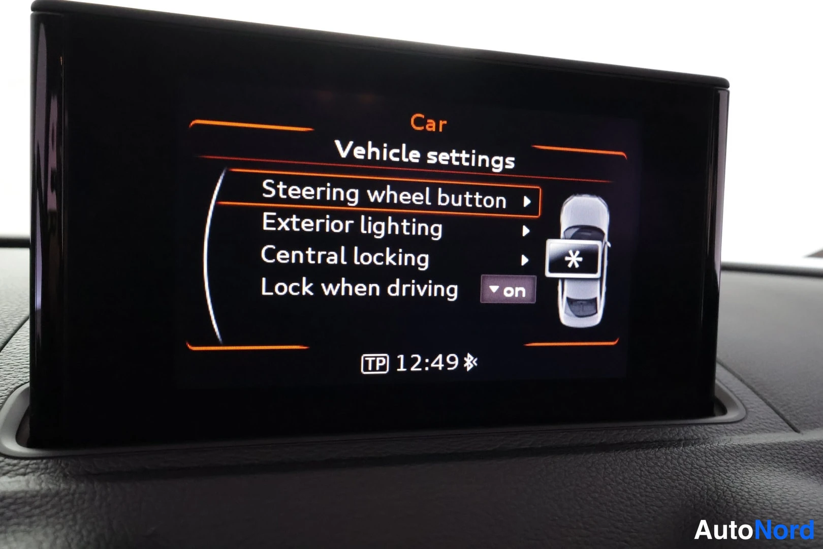 Muu: Audi A3 Sedanin kojelaudan näyttö Vehicle settings -valikossa: Steering wheel button, Exterior lighting, Central locking ja Lock when driving (on), kello 12:49.
