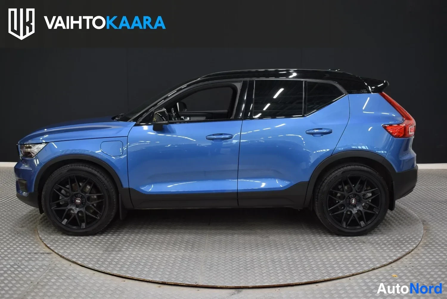 Sivulta: Sininen Volvo XC40 sivulta, mustat kiiltävät vanteet ja musta katto, rekisteritunnus.