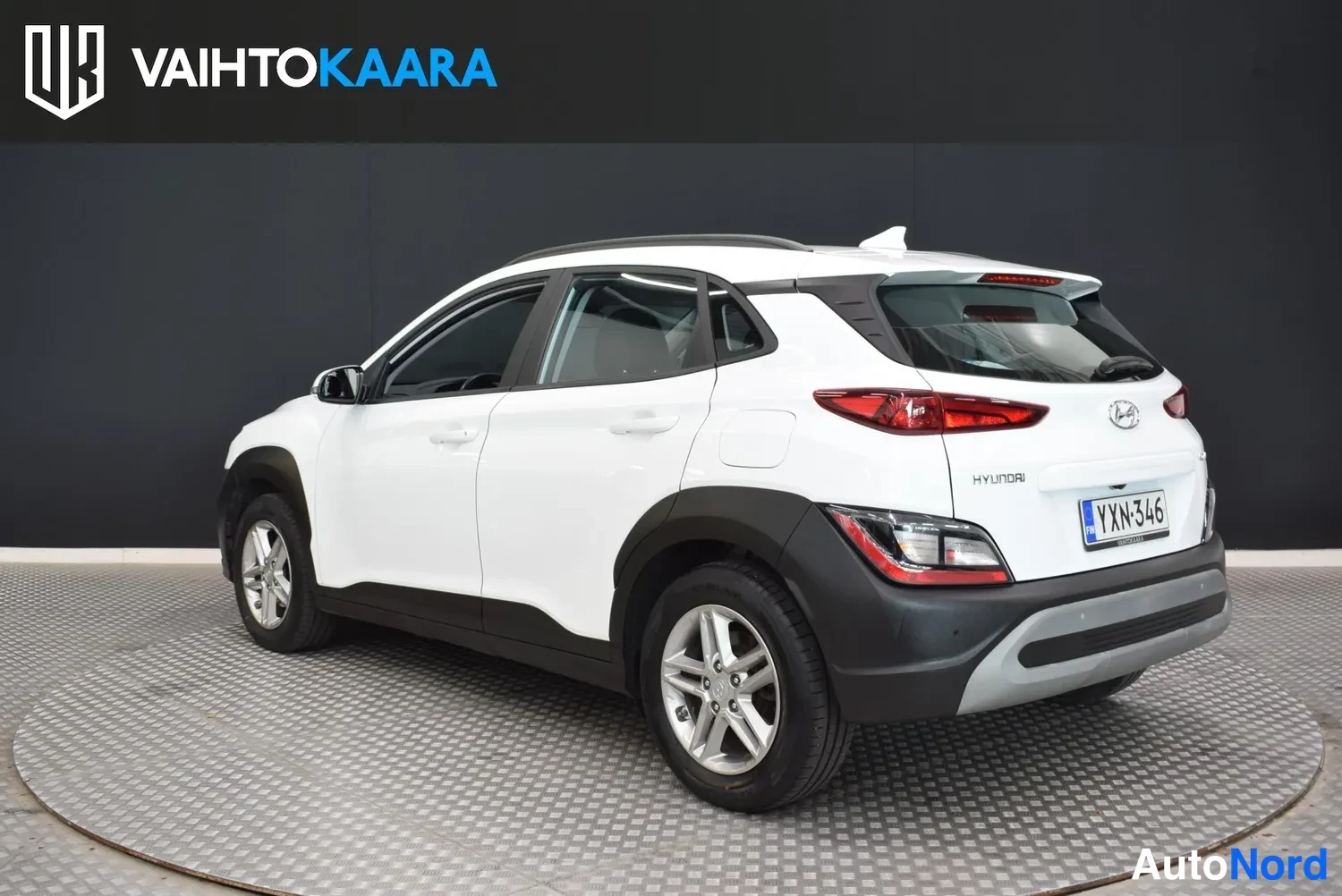 Takaviisto: Hyundai Kona takaa oikealta kuvattuna, valkoinen kori, takavalot ja rekisteri.