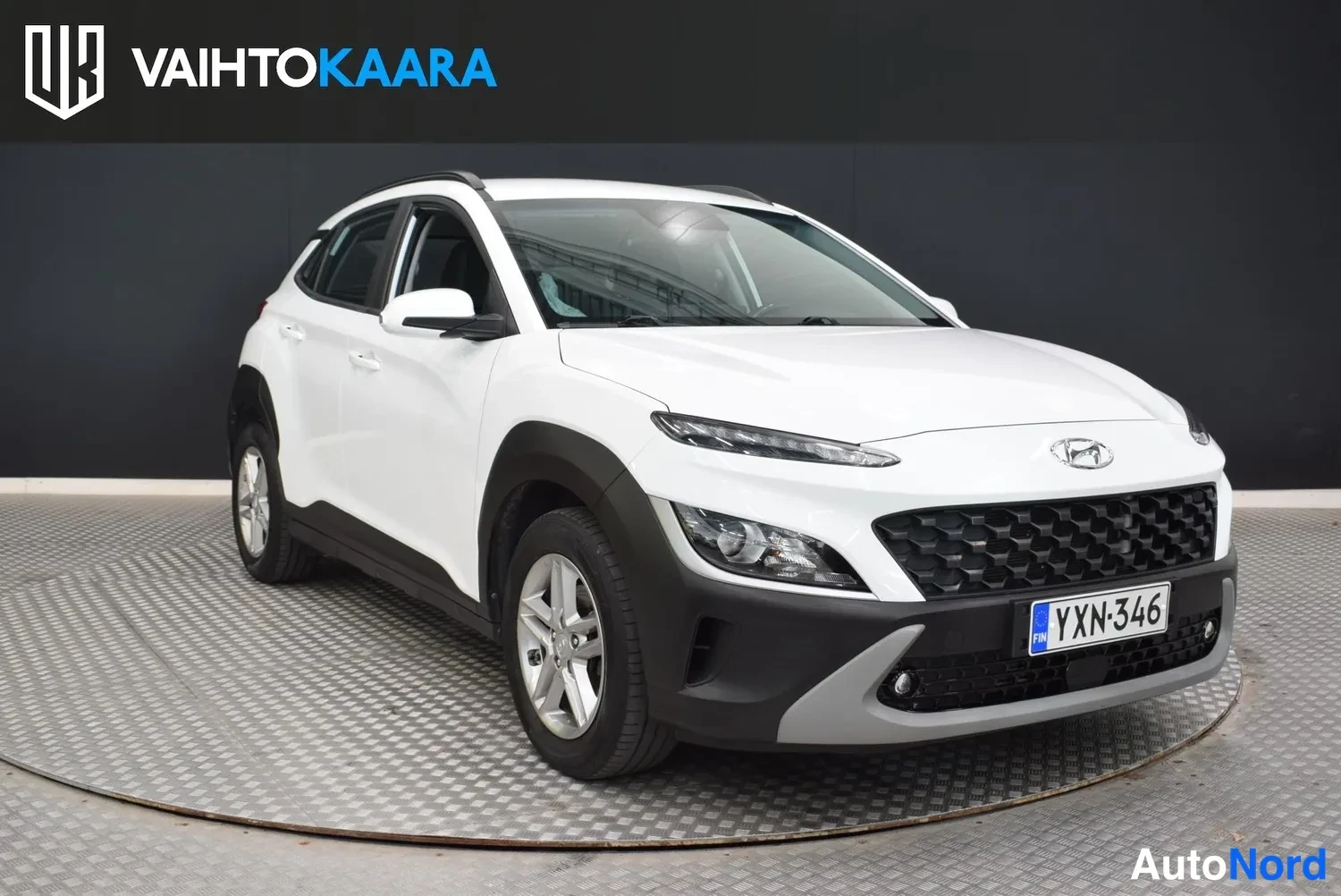 Etuviisto, nokka oikealle: Hyundai Kona etuviistöstä oikealta kuvattuna, valkoinen kori, rekisterikilpi.