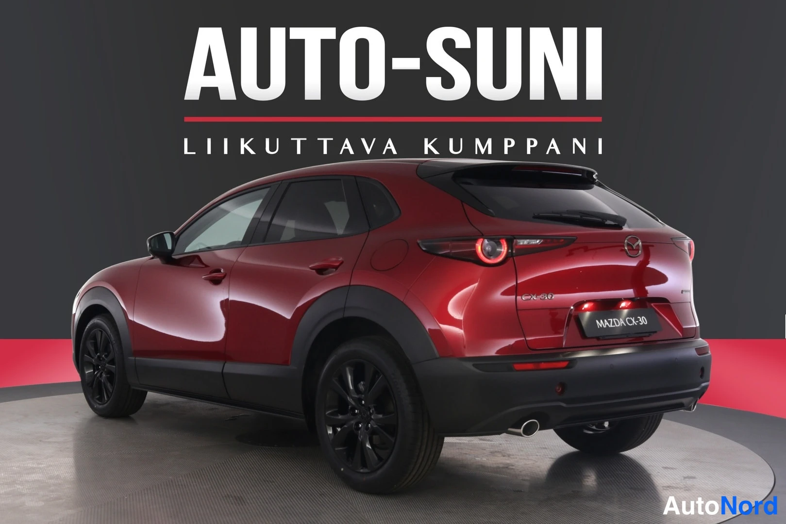 Takaviisto: Punainen Mazda CX-30 takakulma oikealta; takavalot ja takakori näkyvissä, pakoputki.