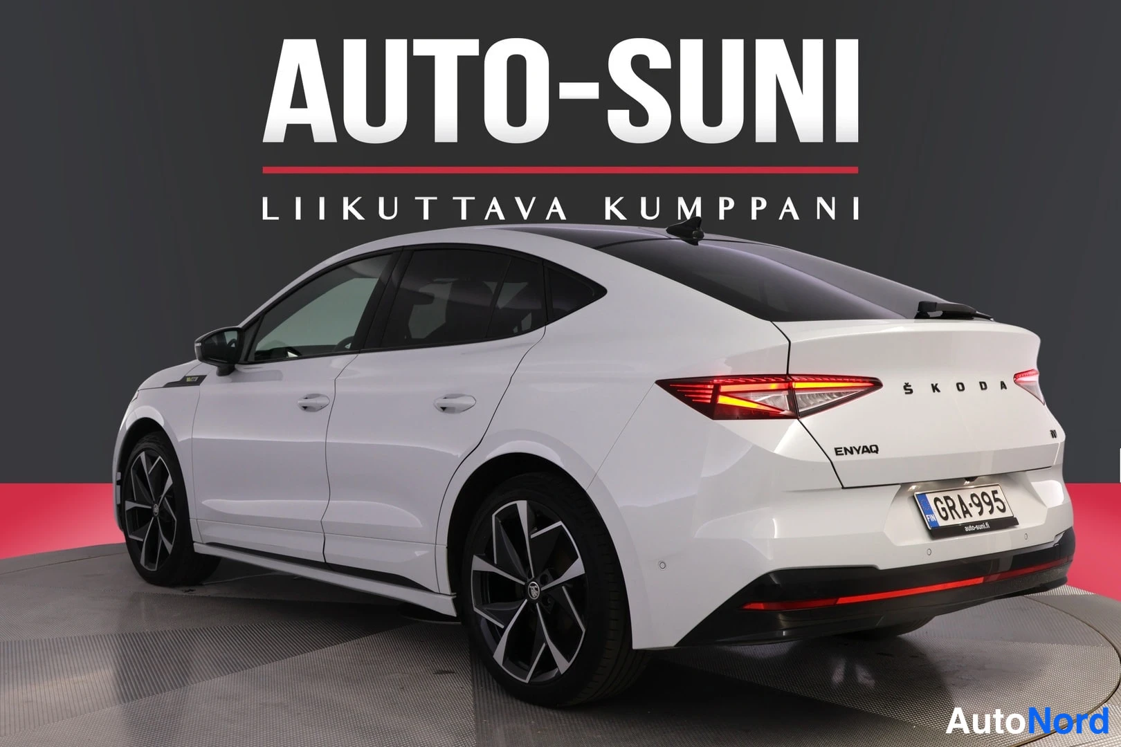 Takaviisto: Auton takakulmanäkymä: valkoinen Skoda Enyaq, takavalot ja rekisterikilpi näkyvissä.