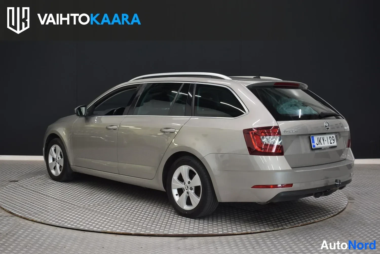 Takaviisto: Skoda Octavia -farmari takaa-oikealta kolmannespisteestä, punaiset takavalot ja rekisterikilpi näkyvissä.