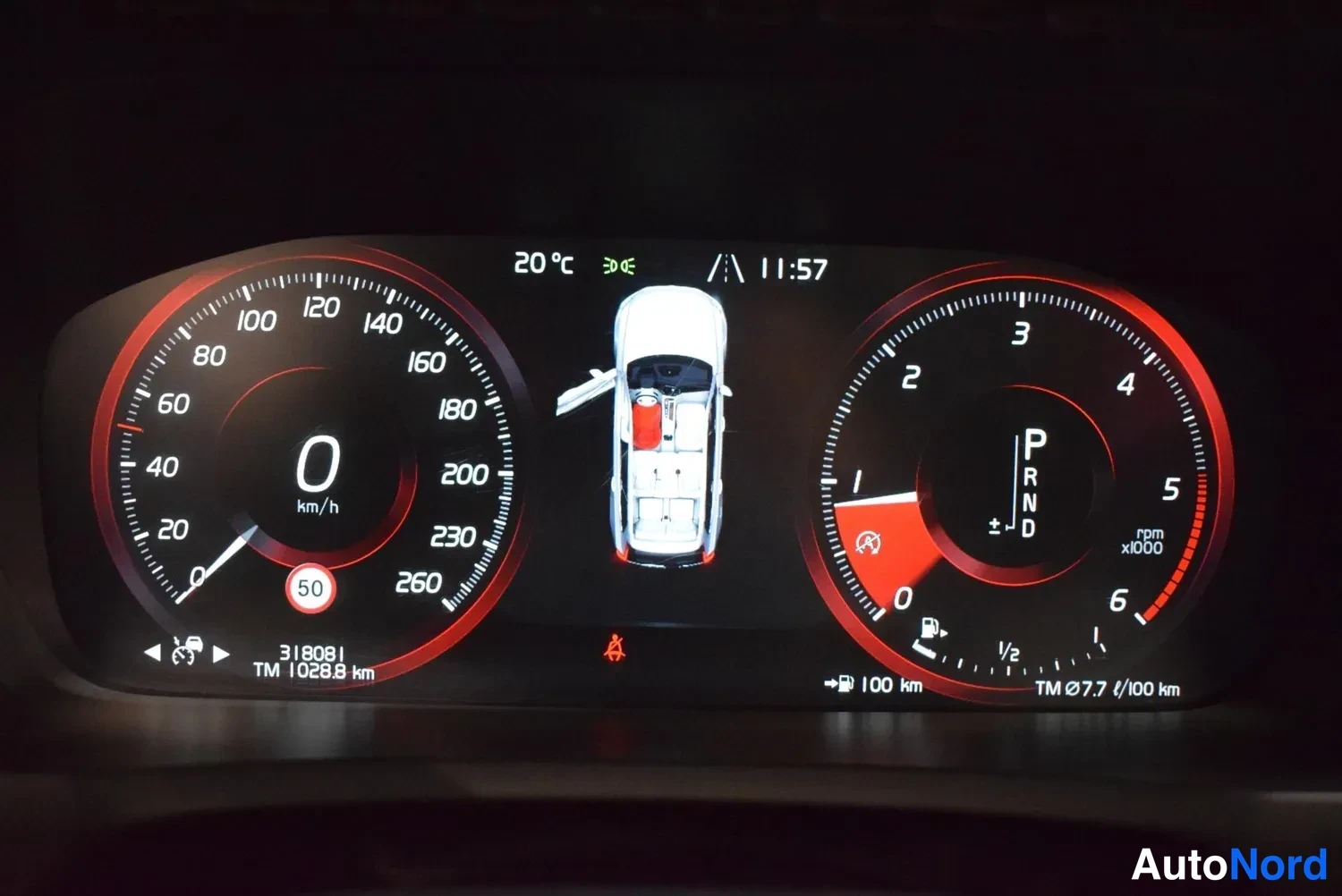 Muu: Instrumenttikilpenä digitaalinen mittaristo: nopeusmittari ja kierrosmittari, vaihde P, lukema 318081 km, ulkolämpötila 20 °c ja kello 11:57.