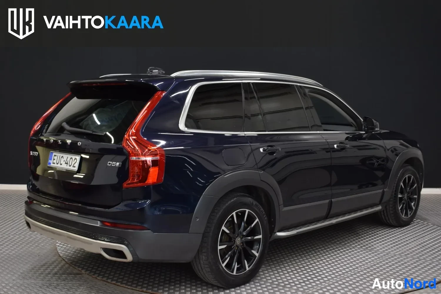Takaviisto: Tummansininen Volvo XC90 -maasturia kuvattu takaa kolmannesvasemmalta studio Lavassa, D5-merkintä ja rekisterikilpi näkyvissä.