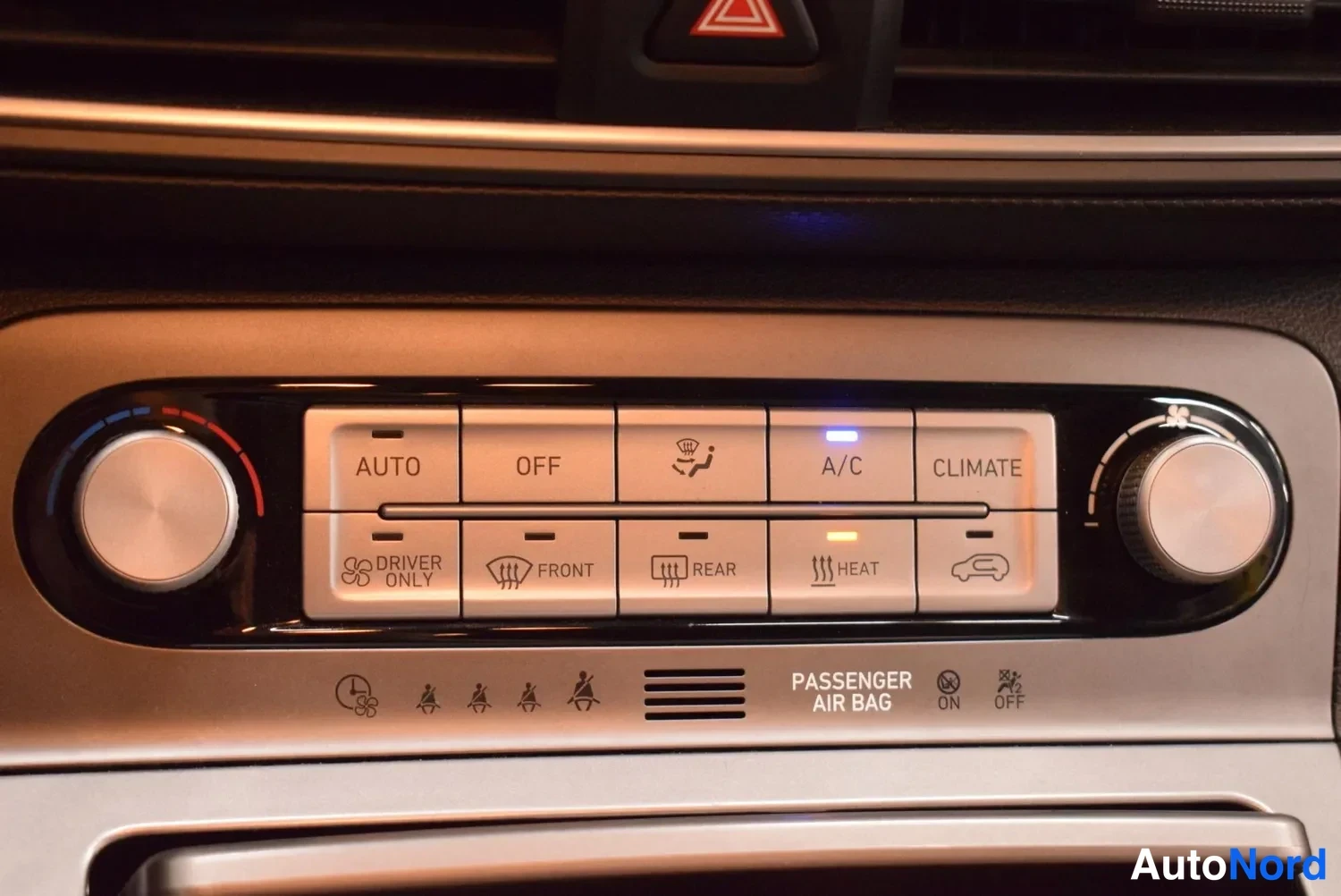 Muu: Keskiö console -ilmastointipaneeli, jossa AUTO, OFF, A/C ja CLIMATE-painikkeet sekä etu- ja takaistuinten lämmitys.