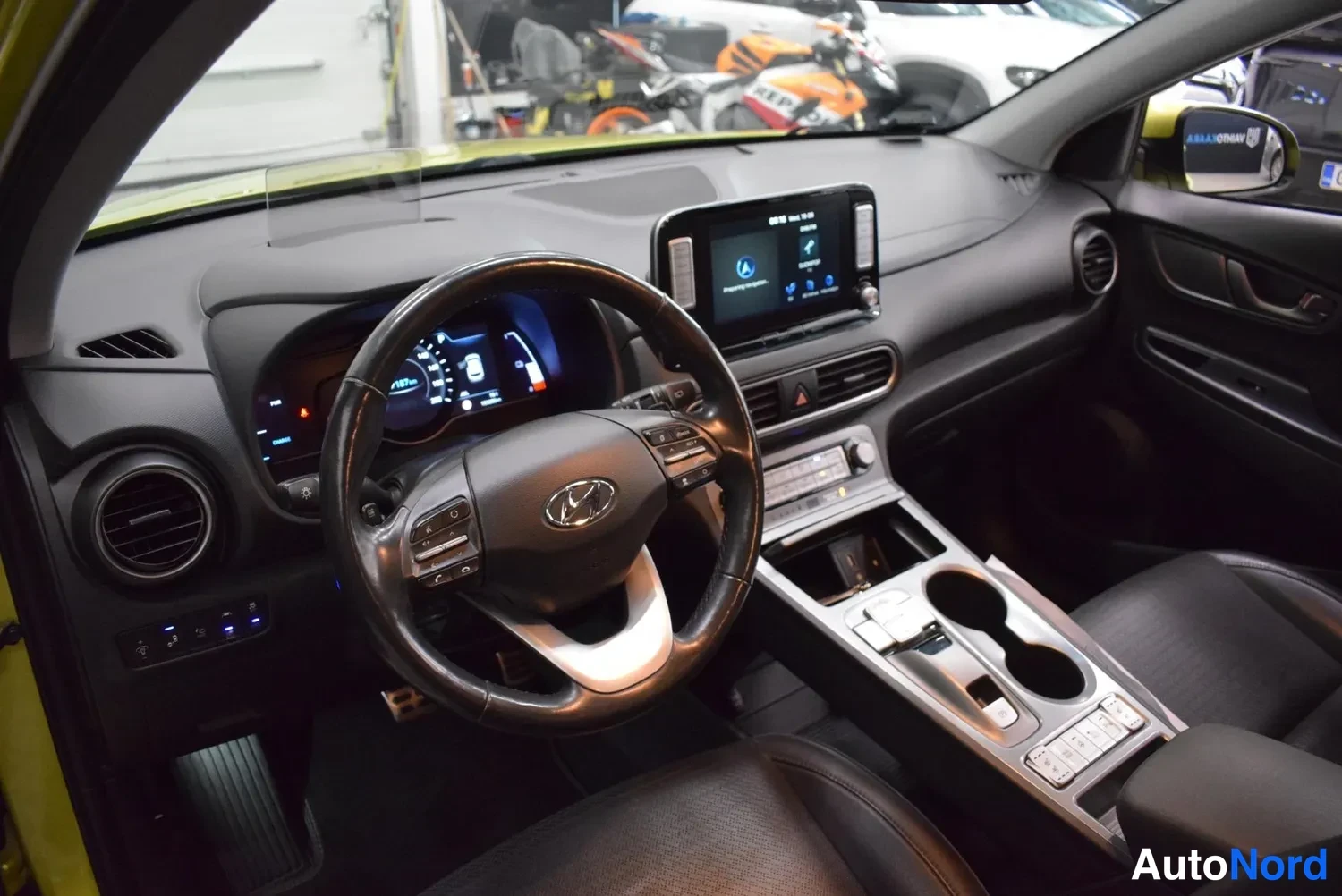 Muu: Hyundai Kona Electricin ohjaamo, monitoimorengas, kosketusnäytöllinen viihdejärjestelmä ja digitaalinen mittaristo, tumma sisusta.