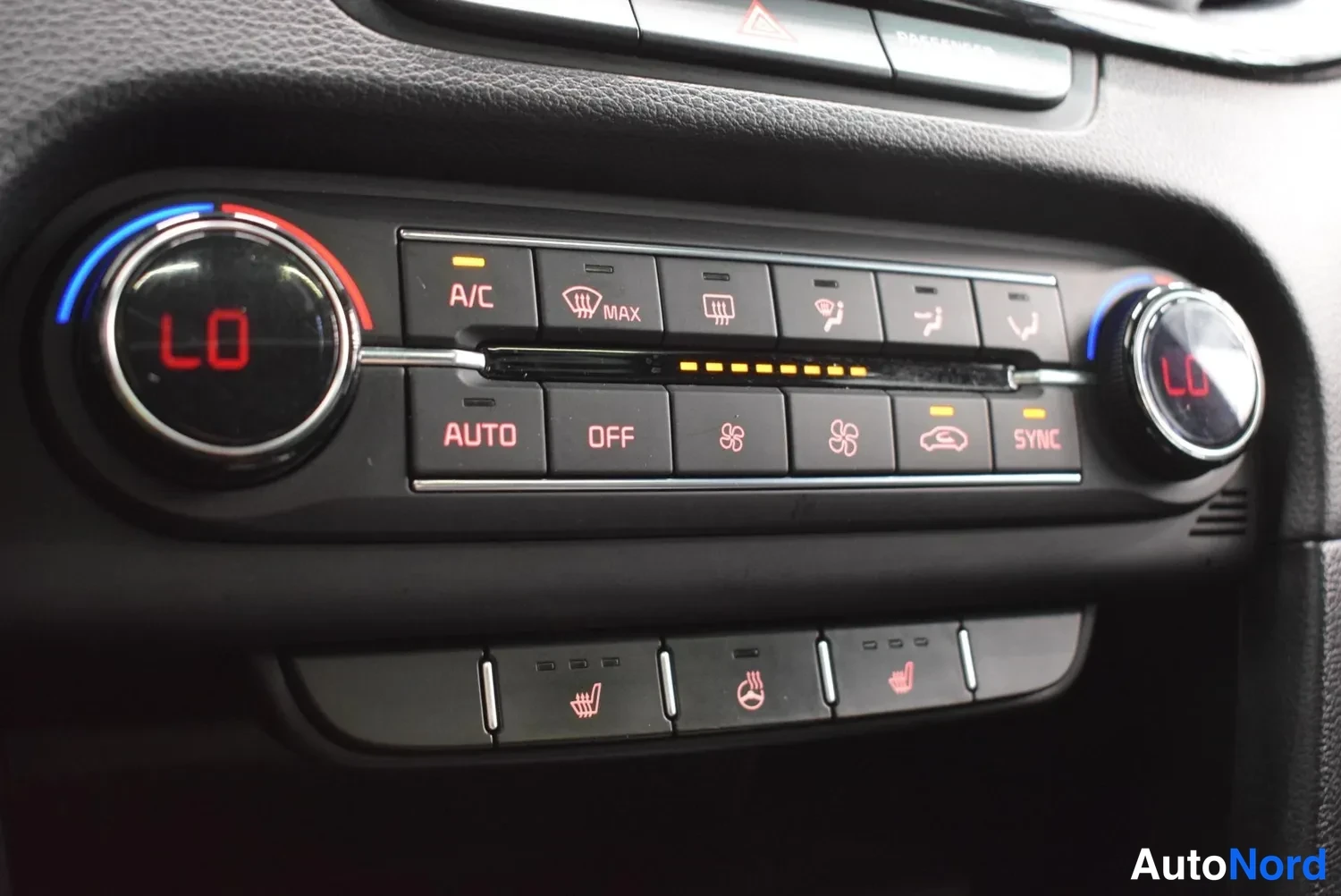 Muu: Auton automaattisen ilmastointilaitteen keskuskonsoli: A/C-, AUTO-, OFF- ja SYNC-painikkeet sekä lämmityspainikkeet.