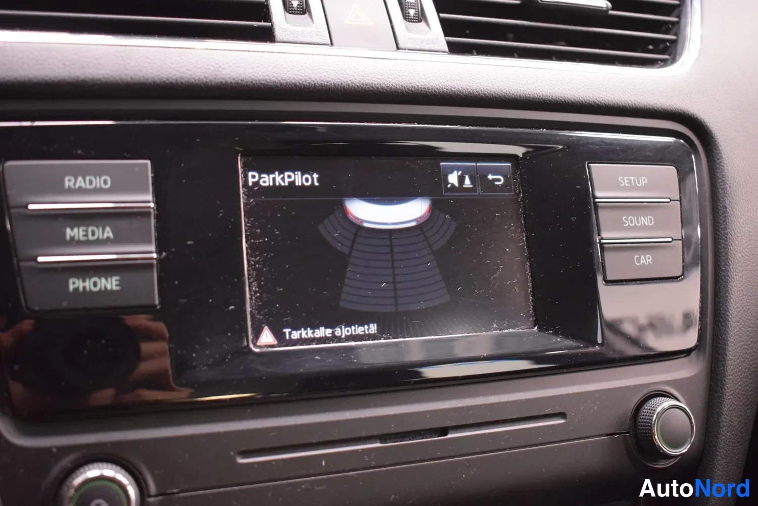 Muu: Radiopaneelin näyttö näyttää ParkPilot-törmäystunnistimen grafiikan ja tekstin Tarkkalle ajotietä!
