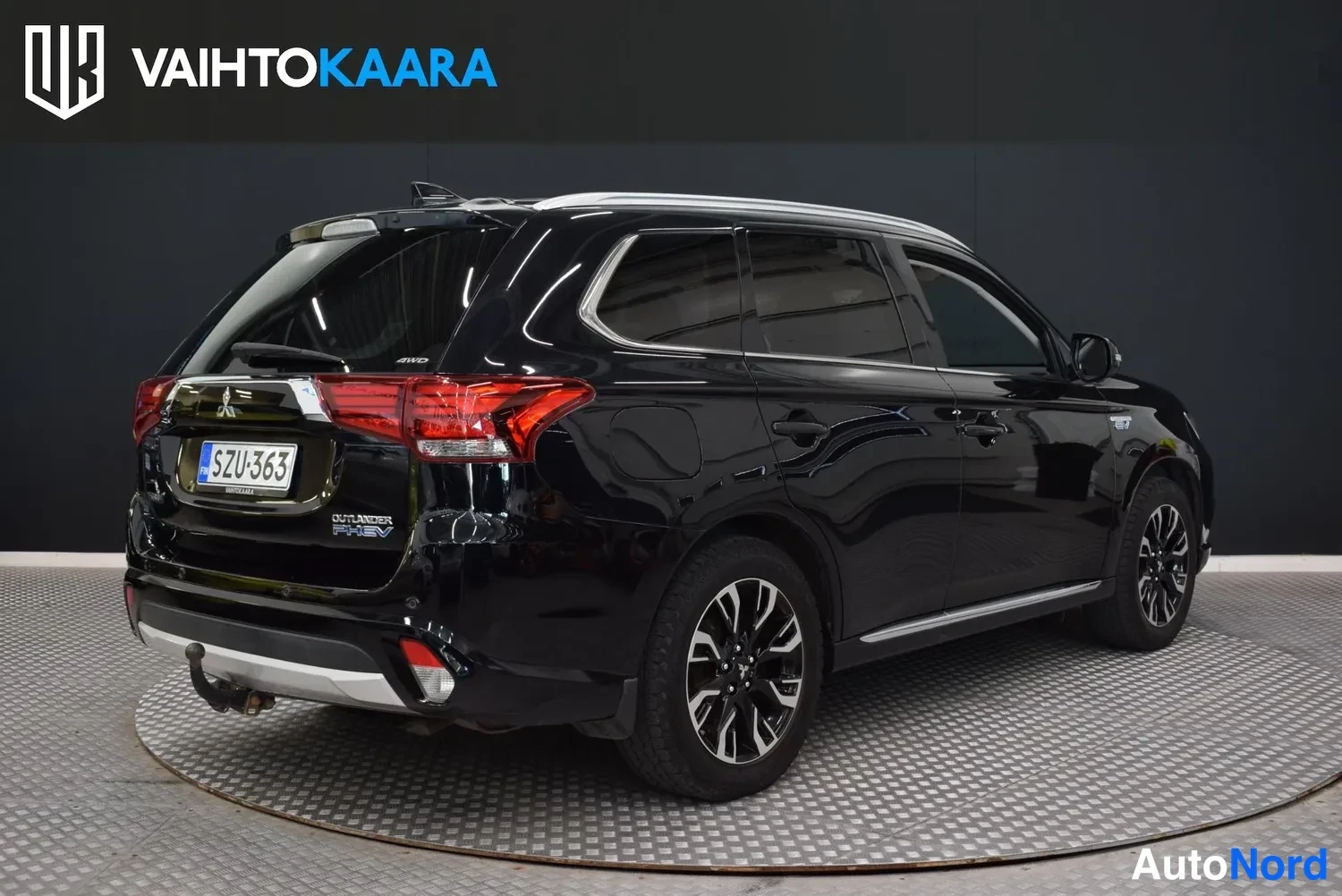 Takaviisto: Mustan Mitsubishi Outlanderin takakulma, perä ja kylki näkyvissä, takaluukussa OUTLANDER PHEV -teksti ja rekisteritunnus.