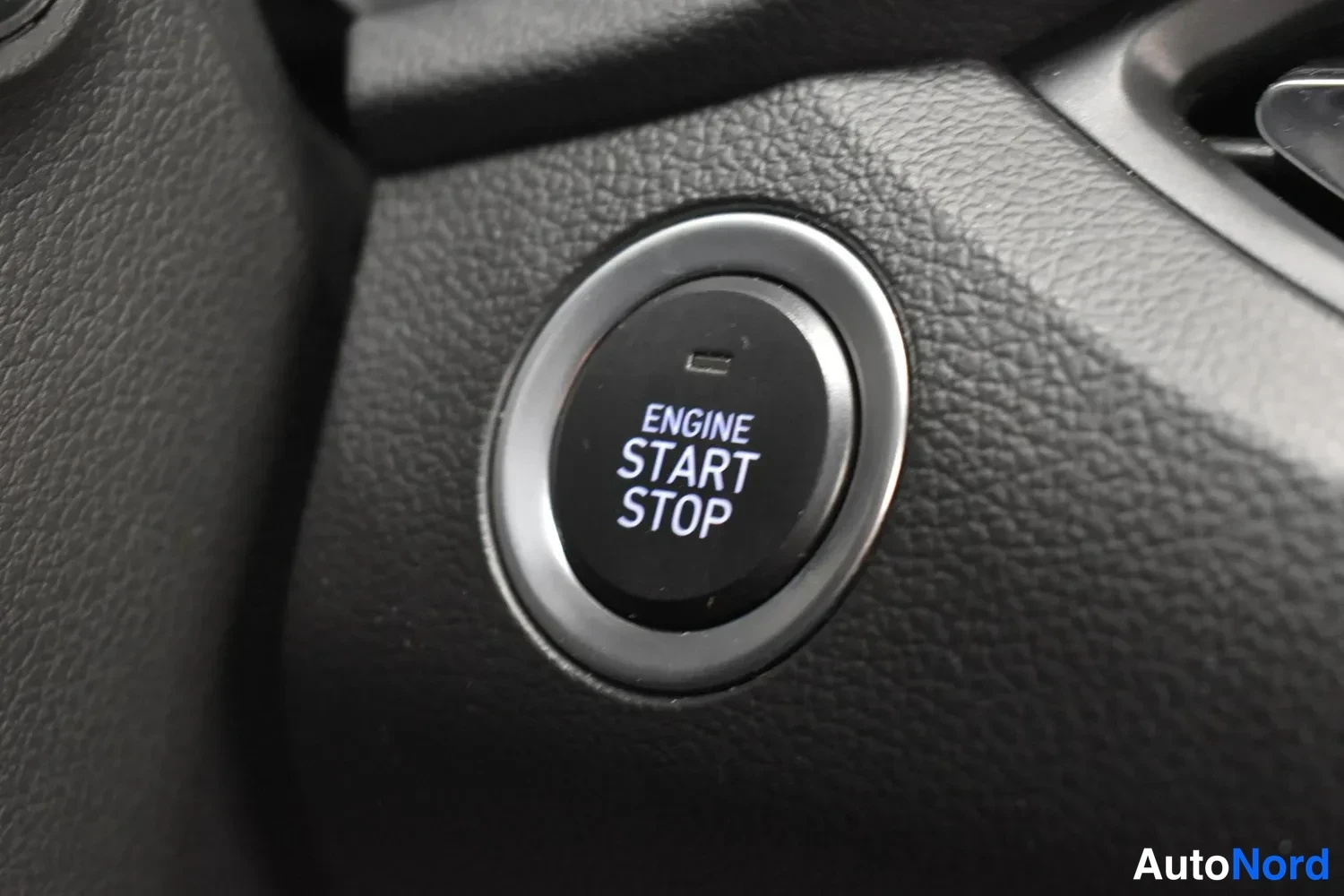 Yksityiskohta: Ohjaamon käynnistyspainike, jossa teksti ENGINE START STOP.