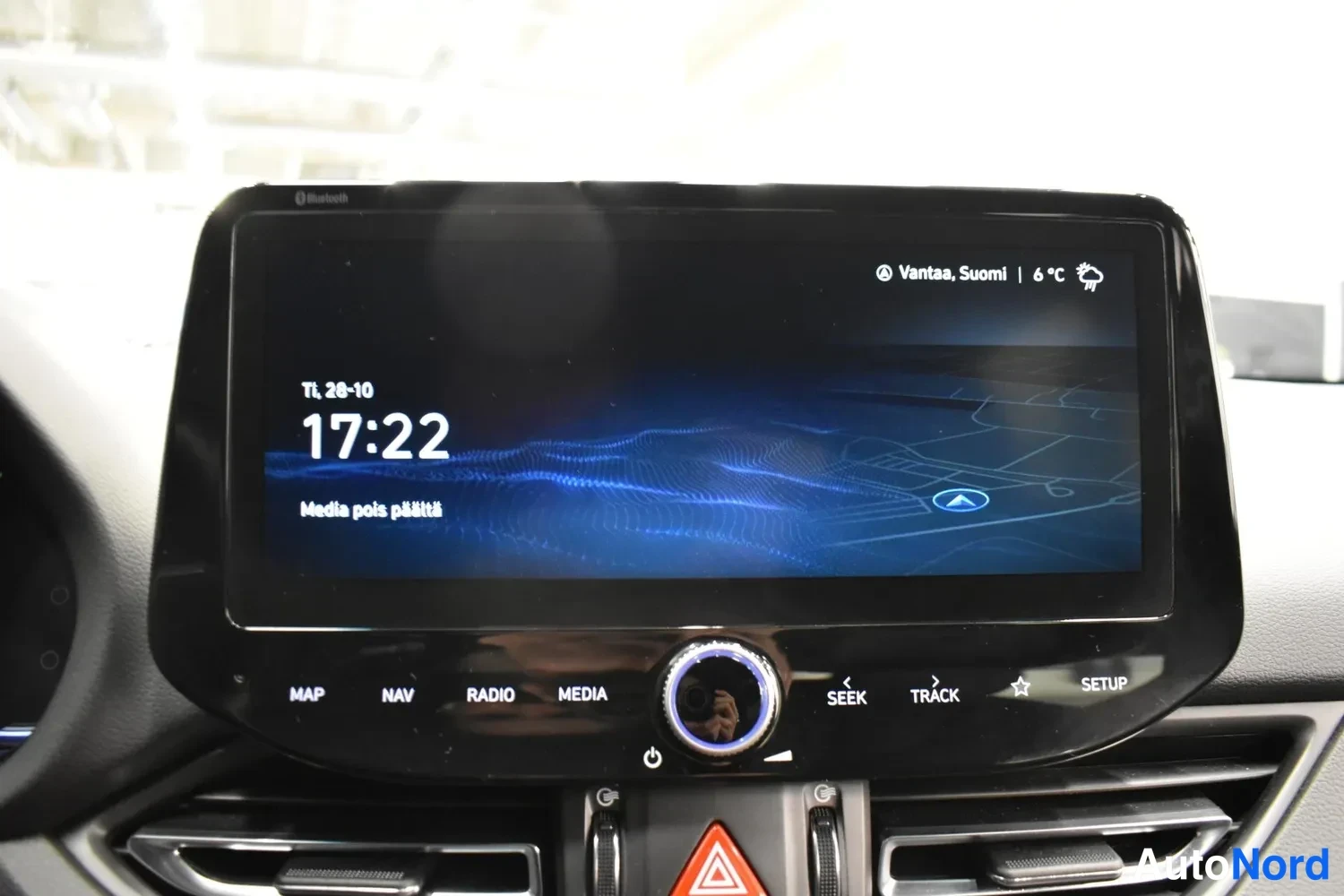 Yksityiskohta: Keskikonsolin infotainment-näyttö kello 17:22, säätiedot Vantaa, Suomi 6 °C, ja painikkeet MAP, NAV, RADIO, MEDIA, SEEK, TRACK, SETUP.