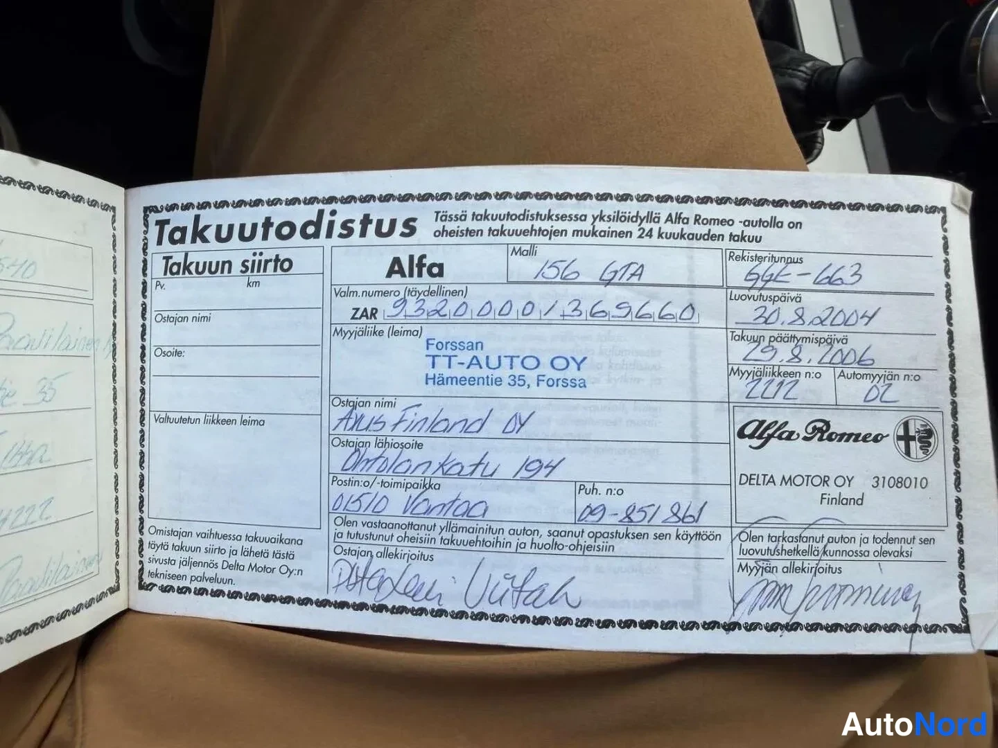 Asiakirja: Avattu Alfa Romeon Takuutodistus -kirjanen, jossa käsialalla täytettyjä tietoja kuten malli 156 GTA, rekisteritunnus ja luovutuspäivä 30.8.2004.