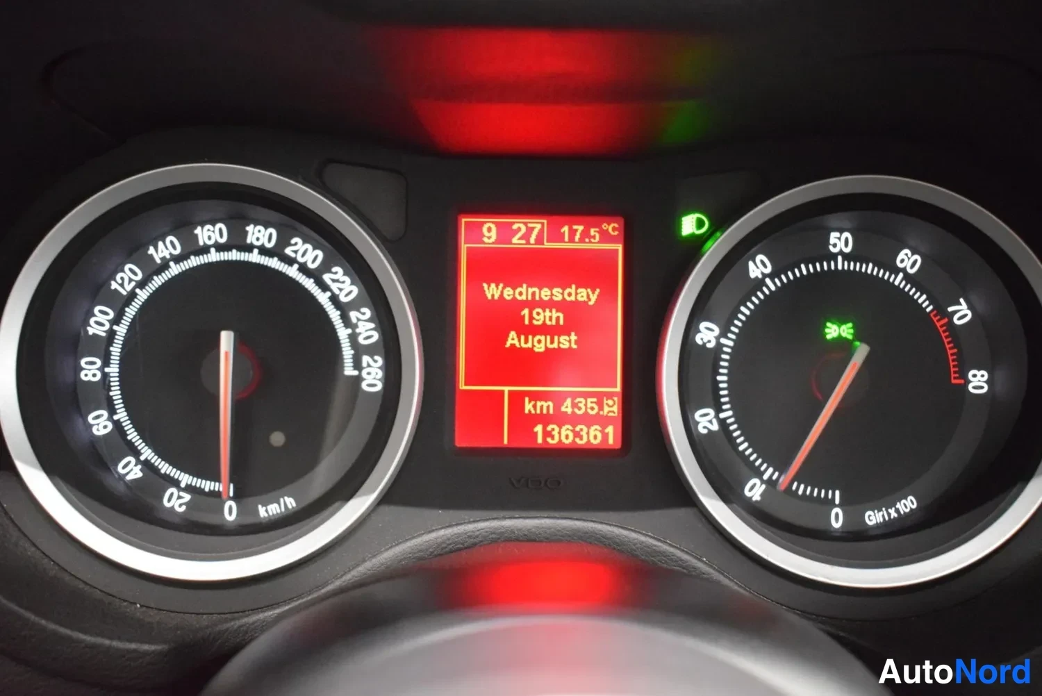 Yksityiskohta: Alfa Romeo -auton mittaristo: nopeusmittari 0–260 km/h, kierrosmittari 0–800 r/min ja punainen näyttö, jossa lukema km 136361 ja teksti Wednesday 19th August.
