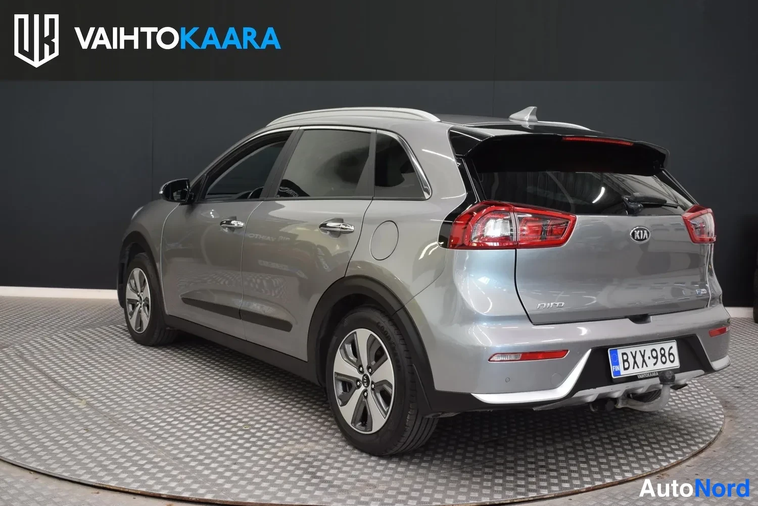 Takaviisto: Kia Niro:n takaosa vasemmalta katsottuna, takavalot, rekisteritunnus ja vetokoukku näkyvät; kattokaiteet kuvan yläreunassa.