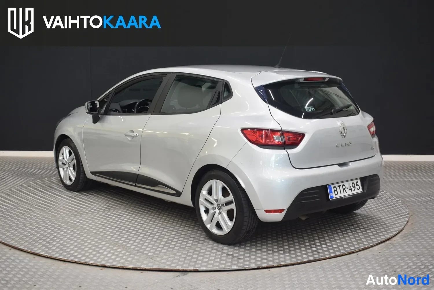Takaviisto: Hopeanvärinen Renault Clio viistosti takaa, perä vasemmalla, rekisterillä.