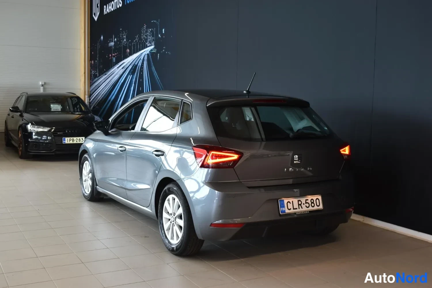 Takaviisto: Seat Ibiza takaa kolmannesvinkkelistä, takavalojen kierrokset syttyneinä, rekisterikilpi.