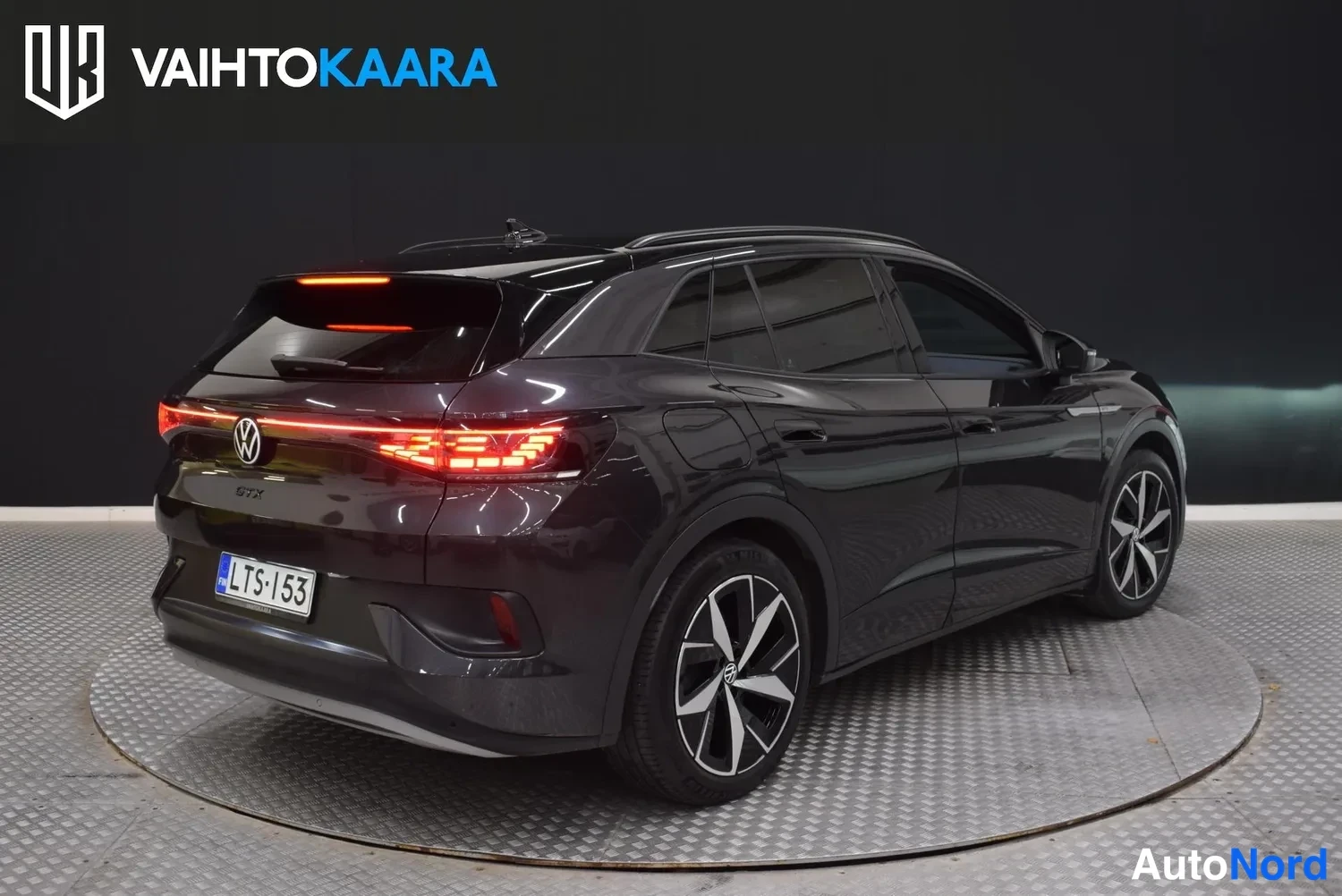 Takaviisto: Tummanharmaa Volkswagen ID.4 takaa oikealta kolmivartalokuvassa, rekisterikilpi.