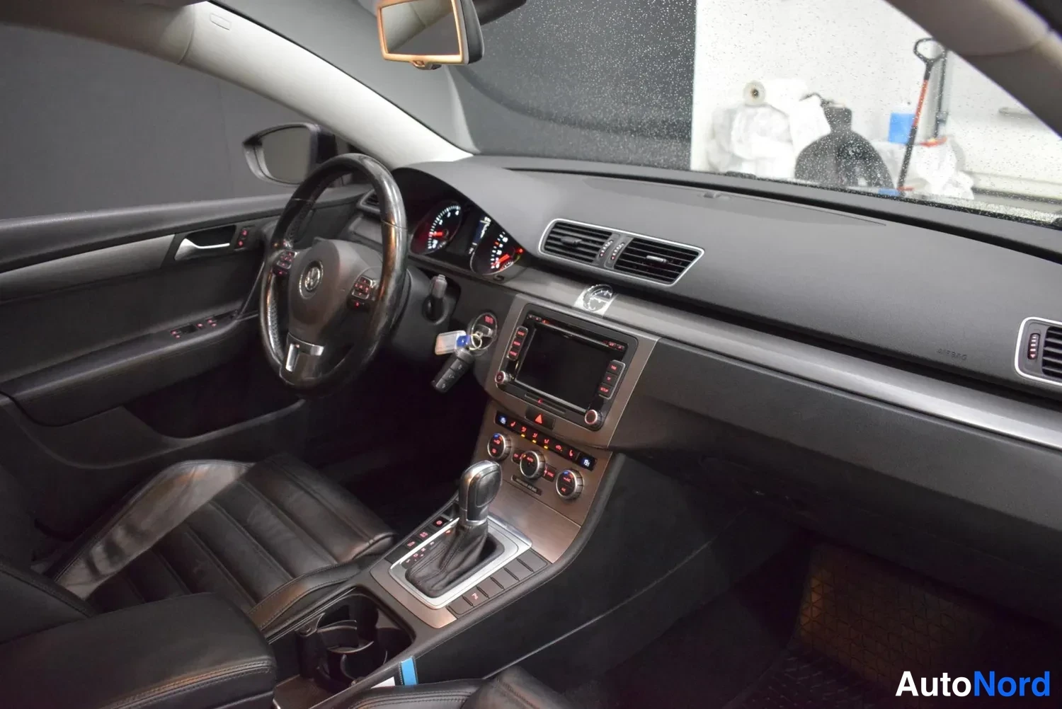 Etuviisto: Kuljettajan näkökulma kojelautaan: VW-logollinen ohjauspyörä, mittaristo, kosketusnäyttö ja automaattivaihteiston valitsin.