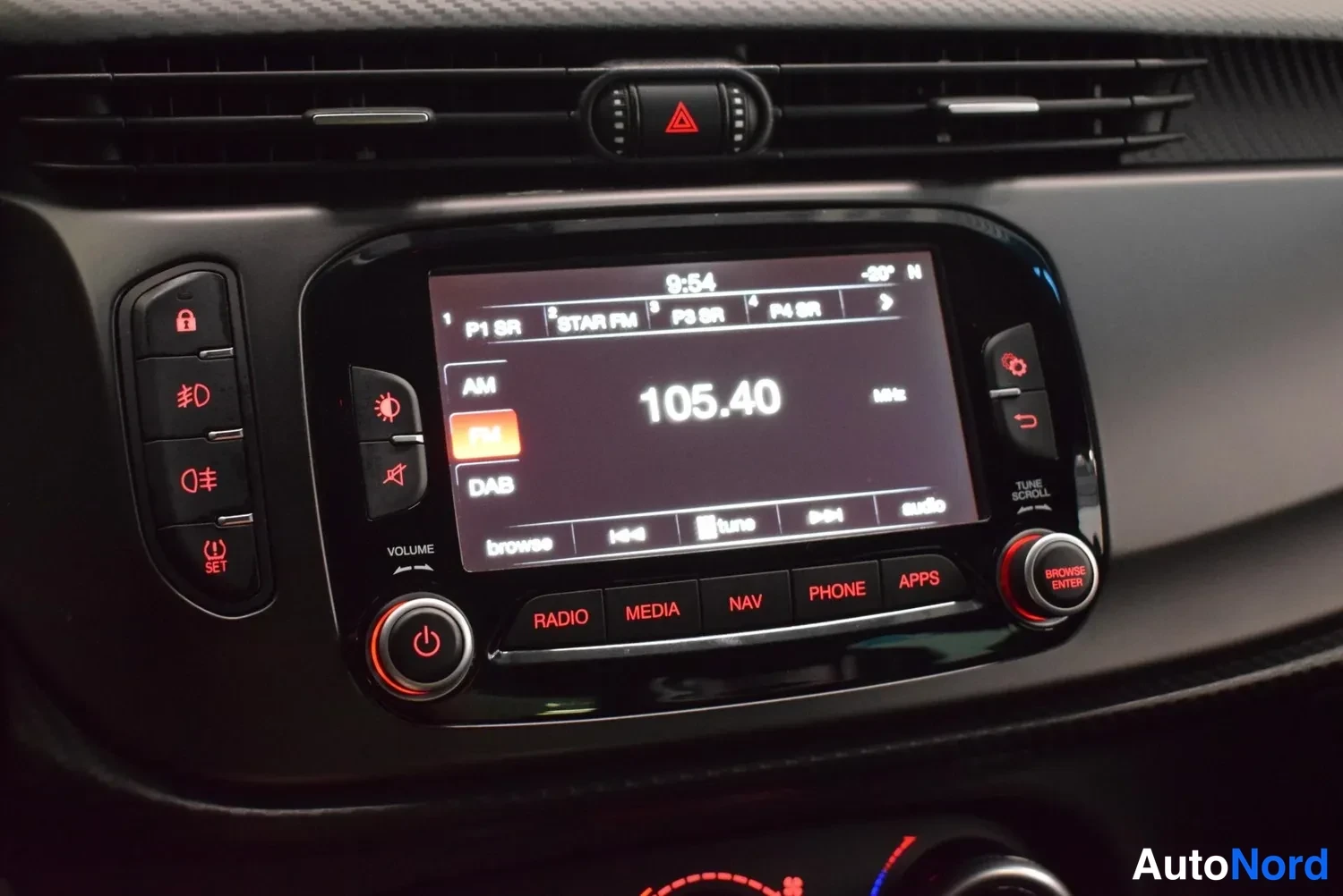 Muu: Keskikonsolin radio- ja navigointinäyttö kanavalla 105.40 MHz, alla painikkeet RADIO, MEDIA, NAV, PHONE, APPS.