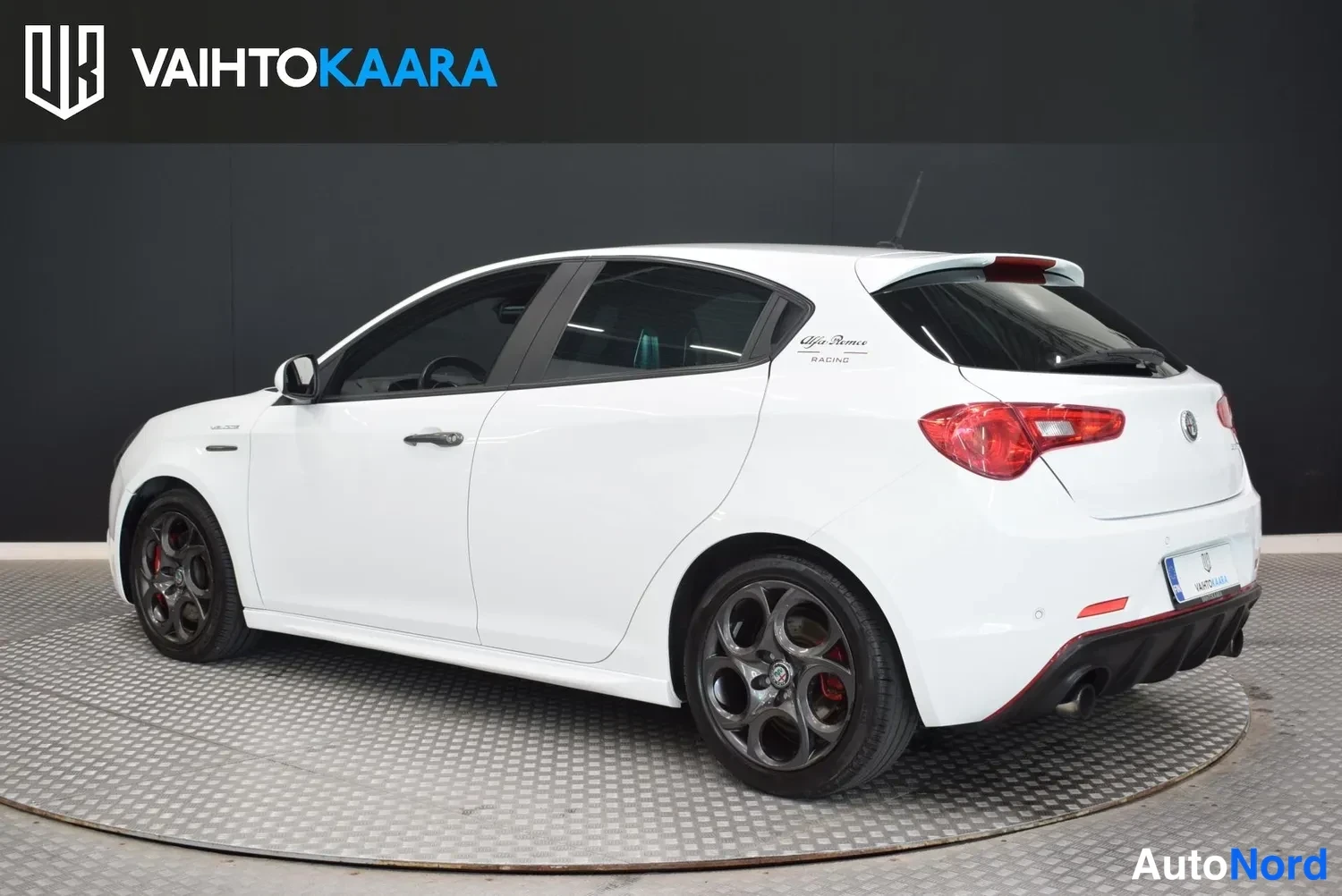 Takaviisto: Valkoinen Alfa Romeo Giulietta -henkilöauto takakulmasta oikealle kuvattuna, punaiset takavalot ja kaksiosainen pakoputki näkyvät.