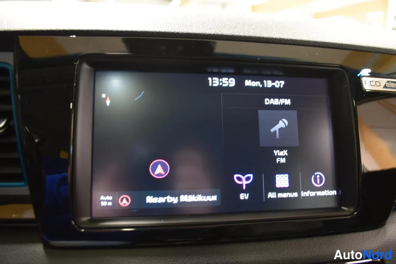 Muu: Infotainment-näyttö näyttää kelloa 13:59, päivämäärää Mon 13-07, DAB/FM-radiota (YleX FM) sekä EV- ja All menus -valikot.