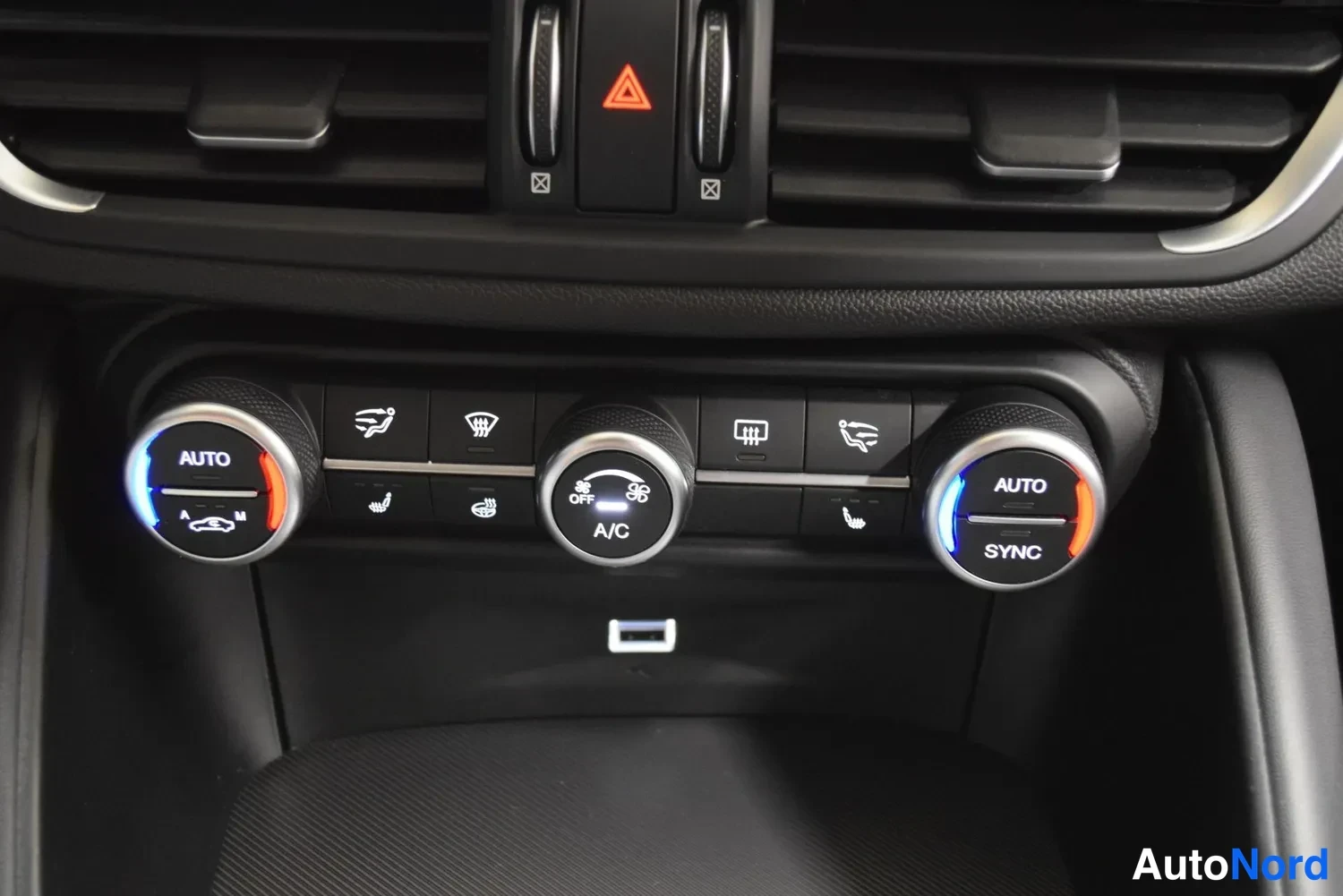 Muu: Keskiöonsoli ilmastointilaitteen säätimillä AUTO- ja SYNC-merkinnoilla sekä A/C-painikkeella ja USB-portilla.