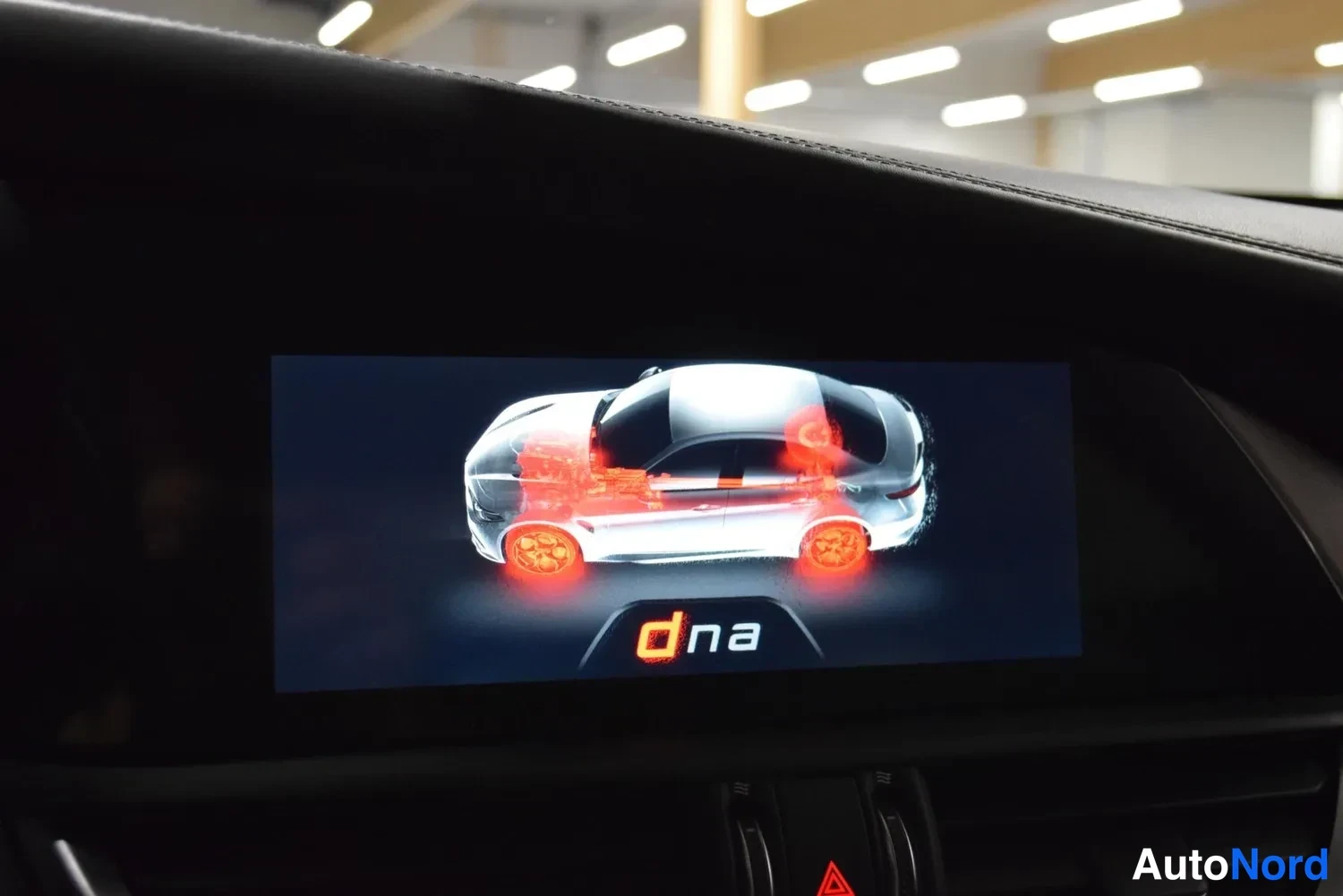 Muu: Infotainment-näyttö näyttää d.na-ajotilan kuvituksen, autonkuvan jossa punaiset pyörät ja voimansiirto korostettuna.
