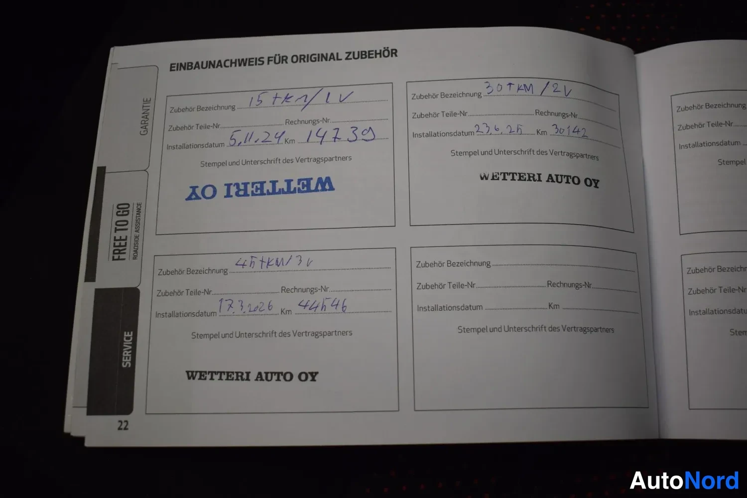 Yksityiskohta: Huoltokirjan sivu 'Einbaunachweis für Original Zubehör' käsinkirjoituksin ja Wetteri Auto OY -leimoilla.