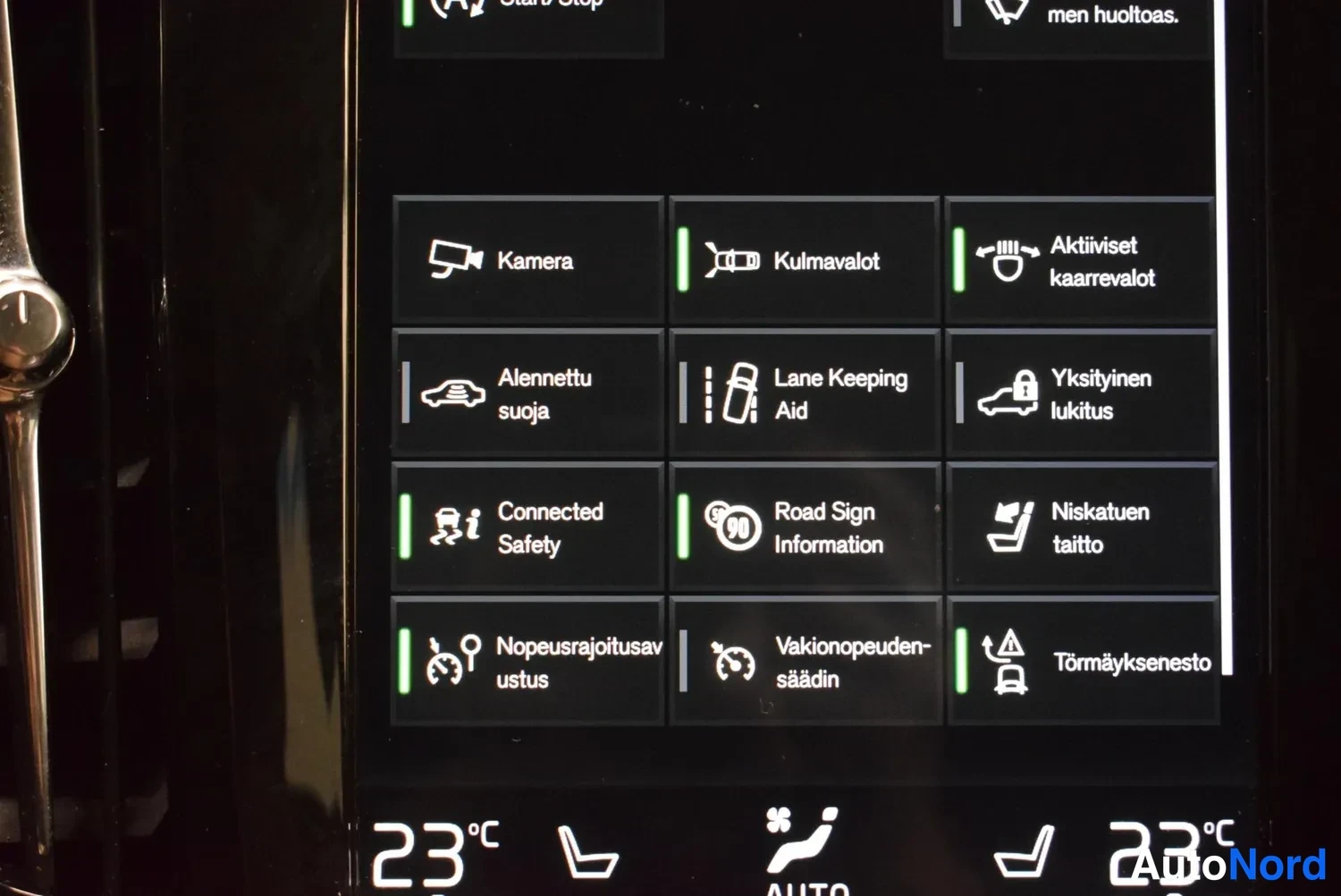Muu: Infotainment-näytön asetusvalikko ruudukossa, jossa kohteet kuten Kamera, Kulmavalot, Aktiiviset kaarrevalot, Lane Keeping Aid, Road Sign Information, Vakionope