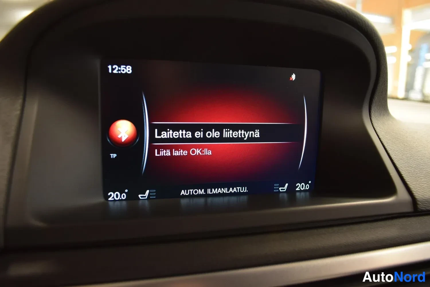 Muu: Kojelaudan näyttö, jossa lukee 'Laitetta ei ole liitetynä' ja 'Liitä laite OK:lla'; kello 12:58 ja molempien penkkien lämpötila 20,0 astetta.
