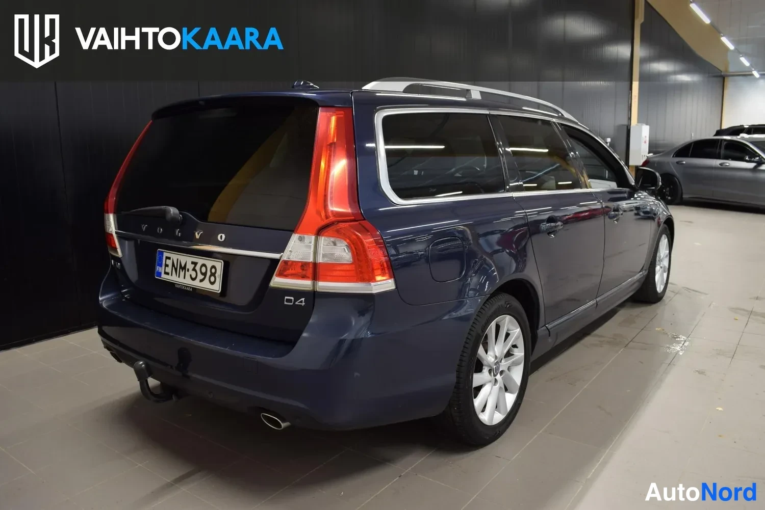 Takaviisto: Sininen farmariauto takanurkasta oikealta sisätiloissa, D4-merkintä takaluukussa, perävaunukoukku ja vanteet näkyvät.