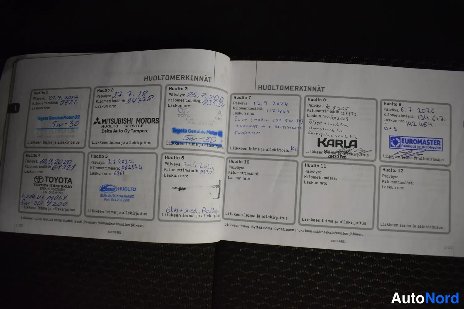Yksityiskohta: Avattu huoltokirja sivuilla otsikolla HUOLTOMERKINNÄT; täytettyjä huoltosoluja leimoilla ja käsialmerkinnöillä, mm. Toyota, Mitsubishi Motors ja EuroMaster.