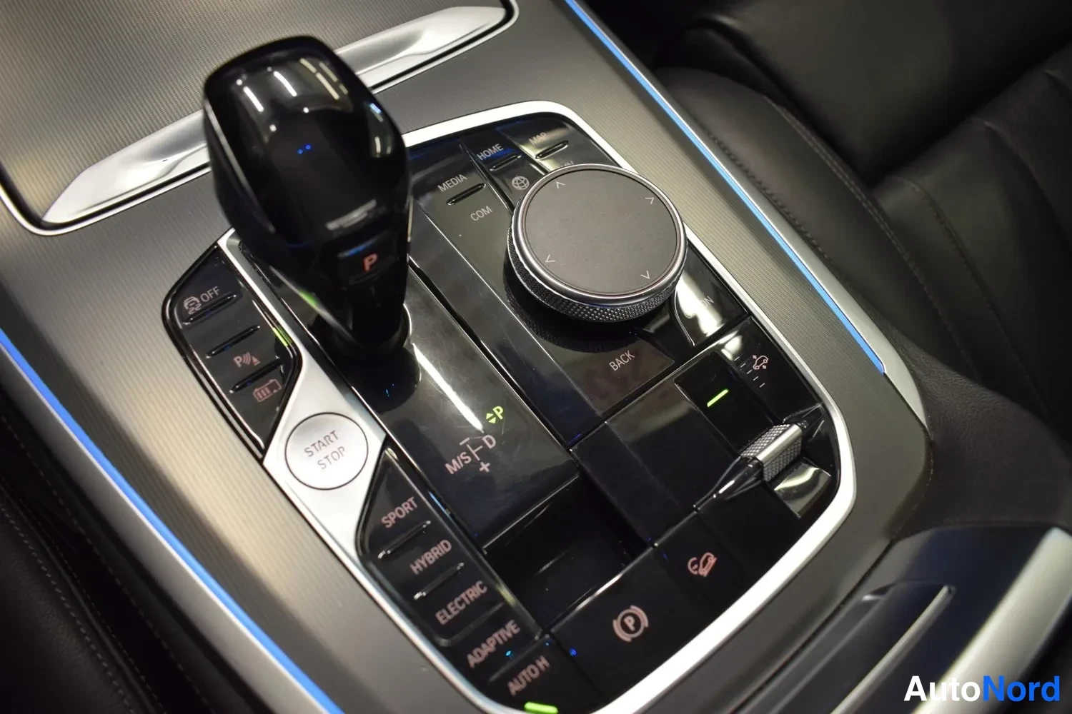 Muu: Keskikonsolin vaihdevalitsin ja iDrive-ohjain, jossa painikkeet START STOP, SPORT, HYBRID, ELECTRIC ja ADAPTIVE.