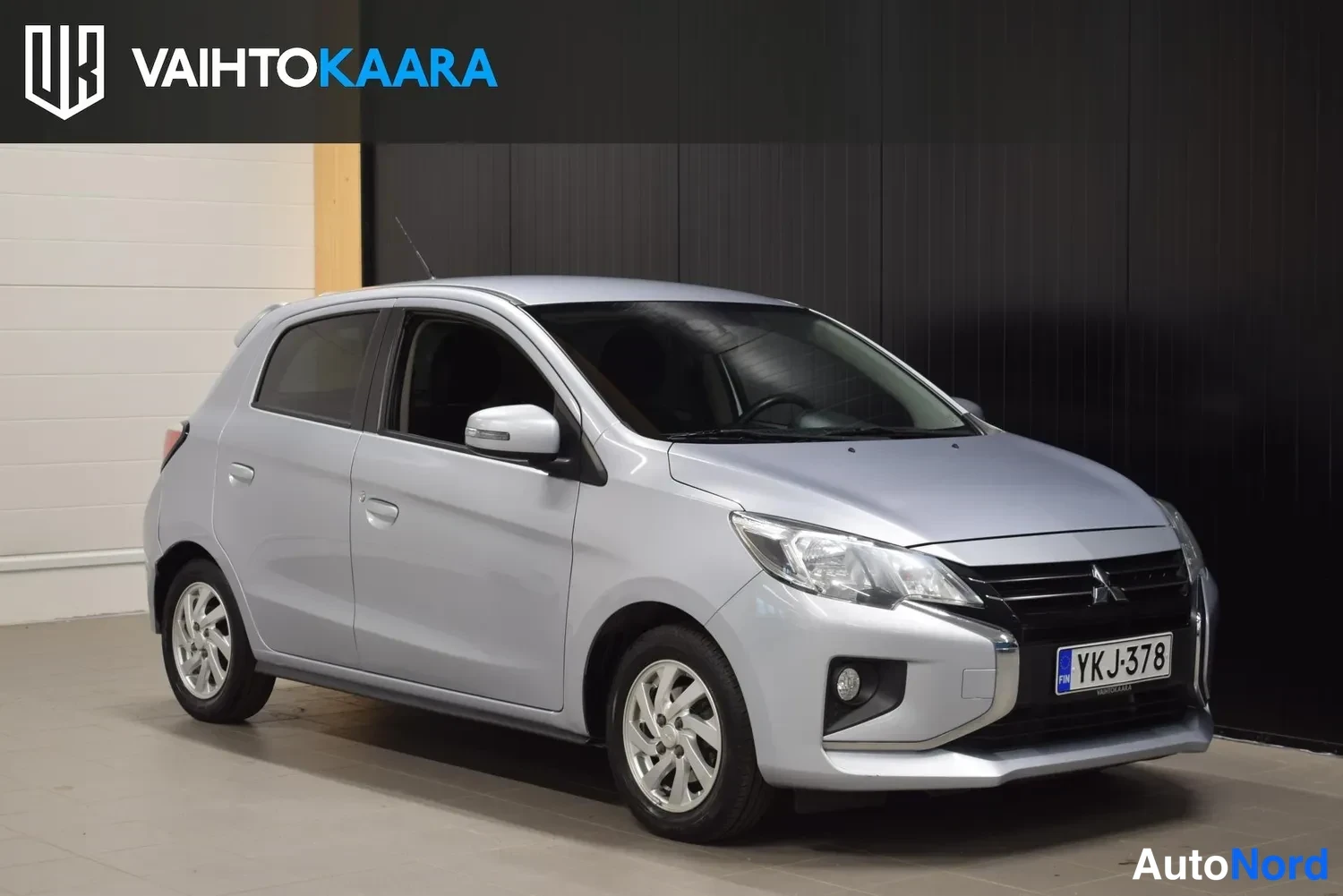 Etuviisto, nokka oikealle: Hopeanharmaa hatchback etulysakulmasta oikealle suunnattuna, rekisterikilpi näkyvissä.