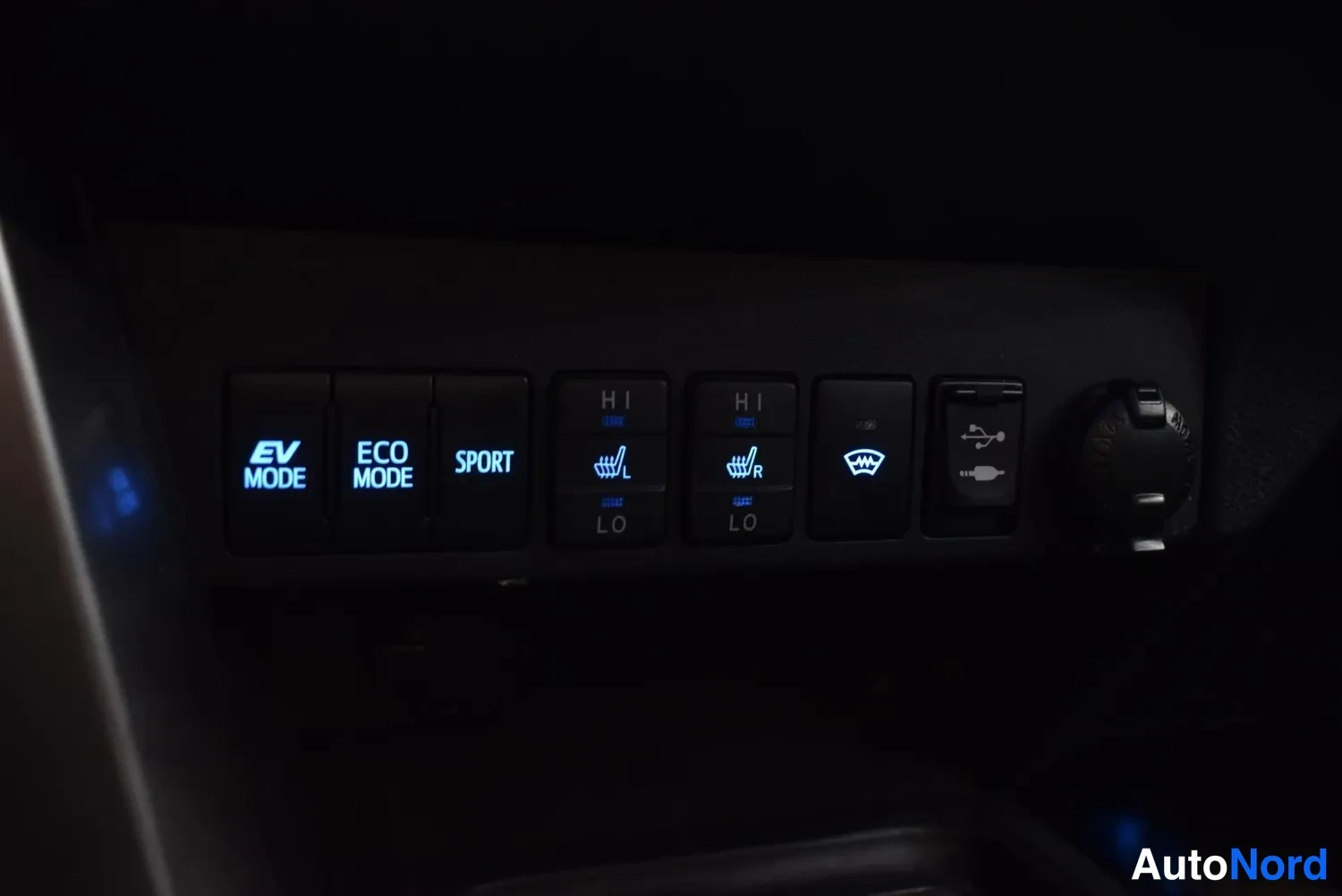 Yksityiskohta: Kojeistorata: EV MODE-, ECO MODE- ja SPORT-painikkeet, lämmitettävien istuinten H/LO-kytkimet vasemmalle ja oikealle, tuulilasin lämmityspainike, USB-pistoke ja