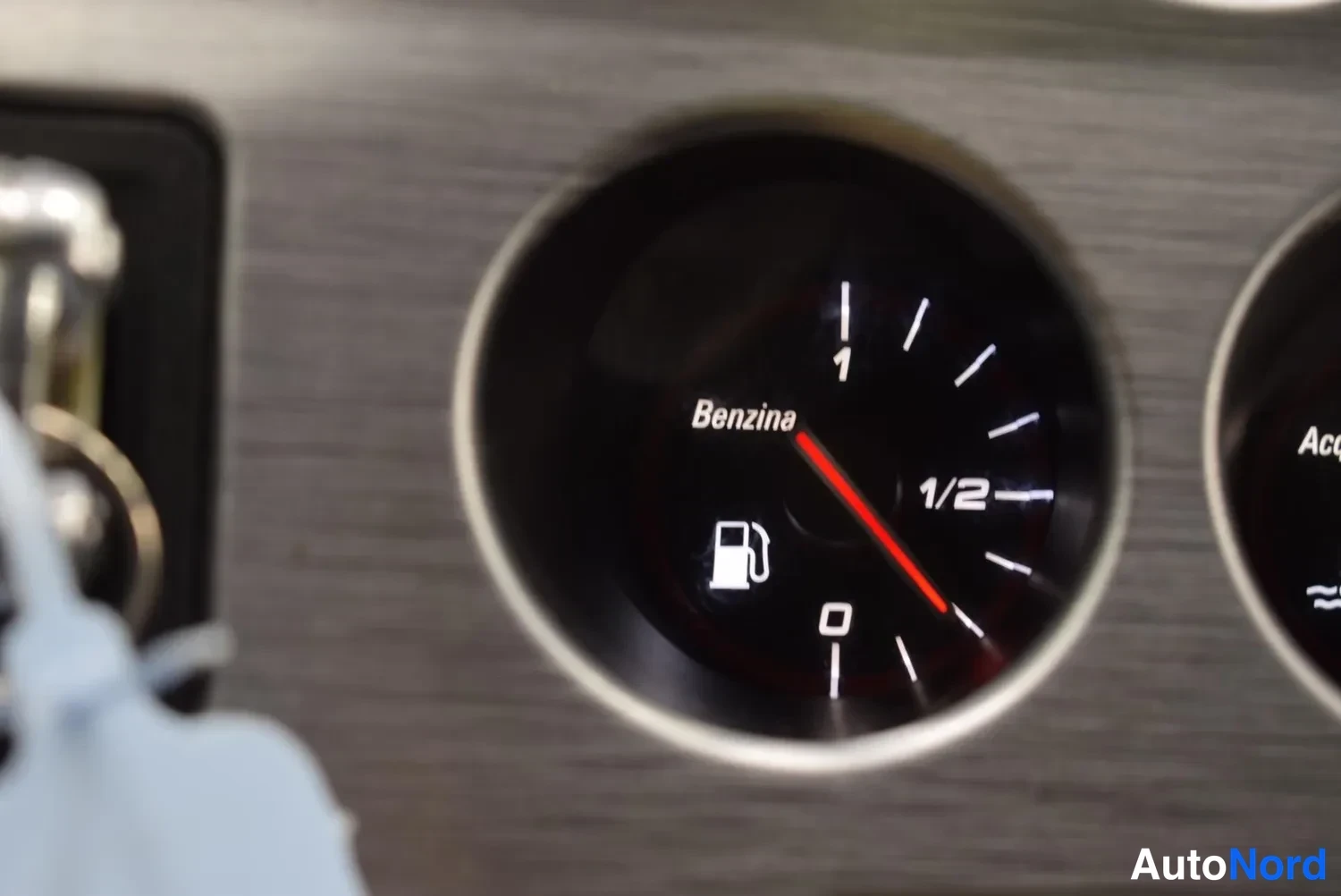 Muu: Sisäkuva: kojelautaan mittari Benzina 0-1-1/2-asteikolla ja polttoainepumpun symboli, viisari alle 1/2.