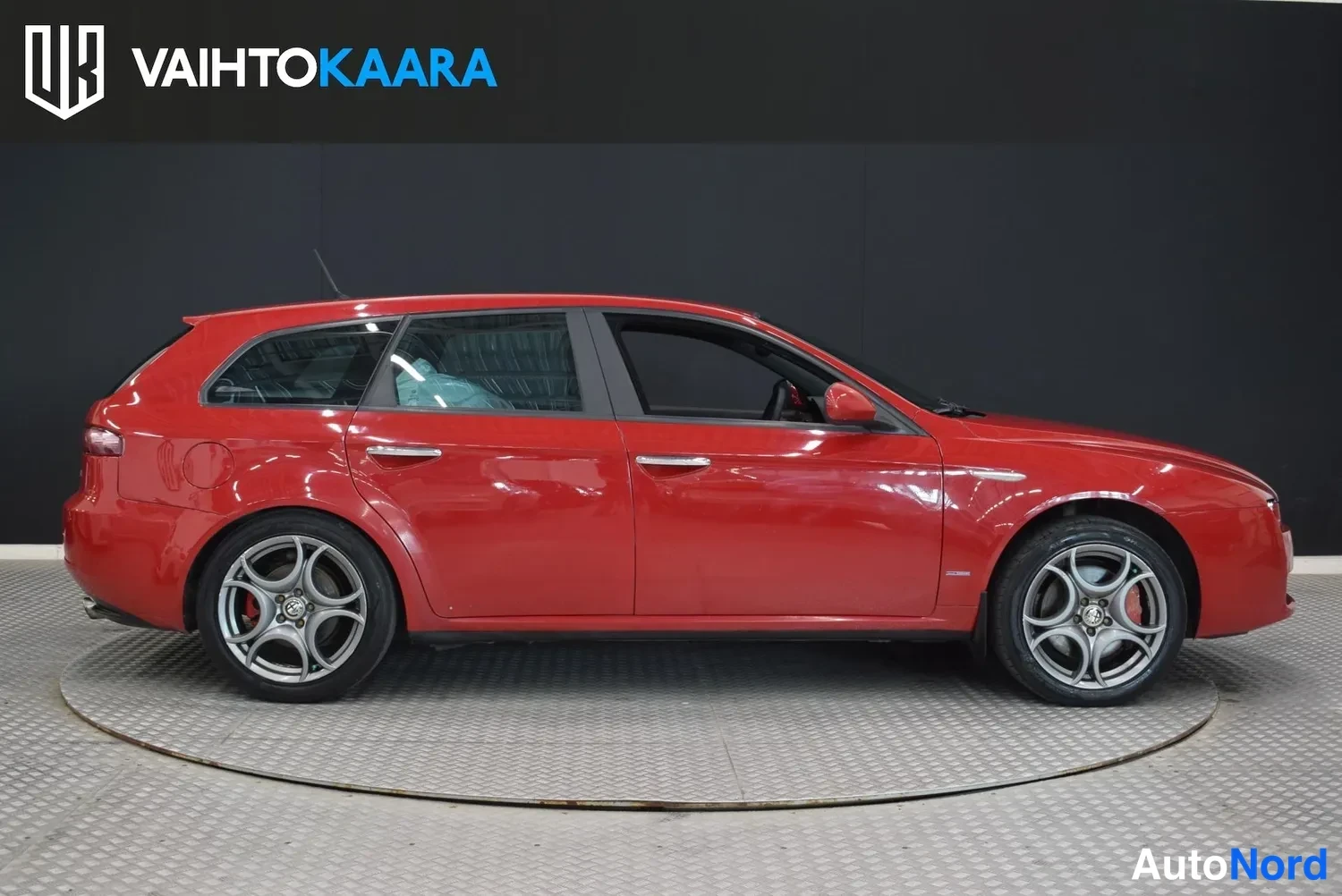 Sivulta: Punainen farmarivaihtoauto sivusta kuvattuna studio-olosuhteissa.
